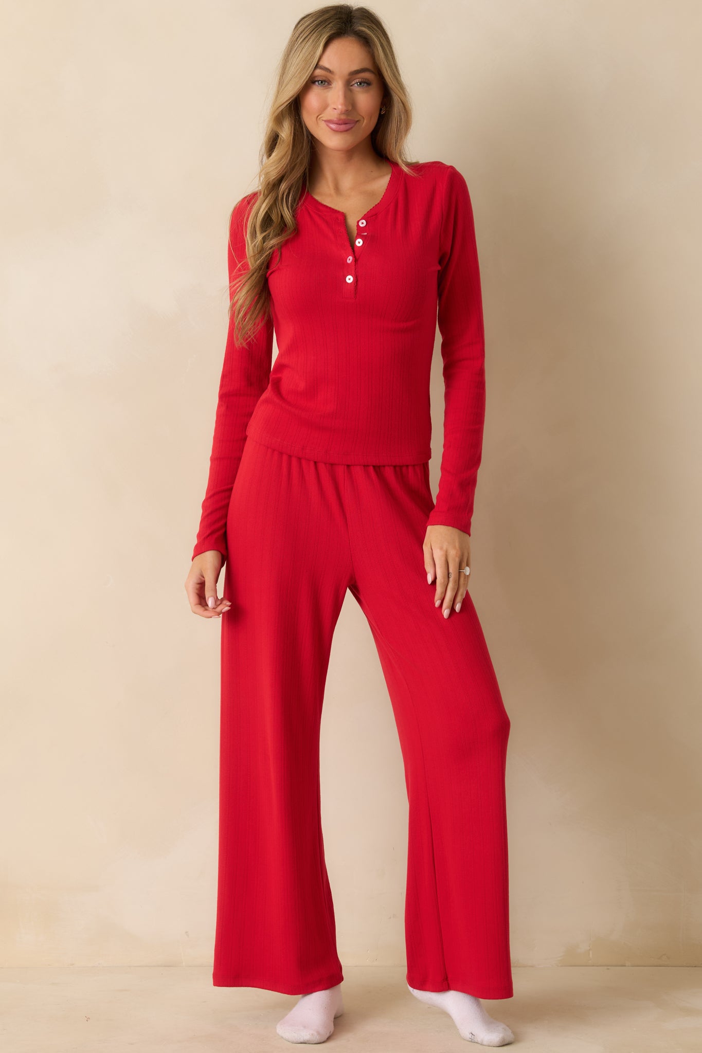 High-rise red pants with a soft-wash finish, draping in a relaxed, full-length silhouette.