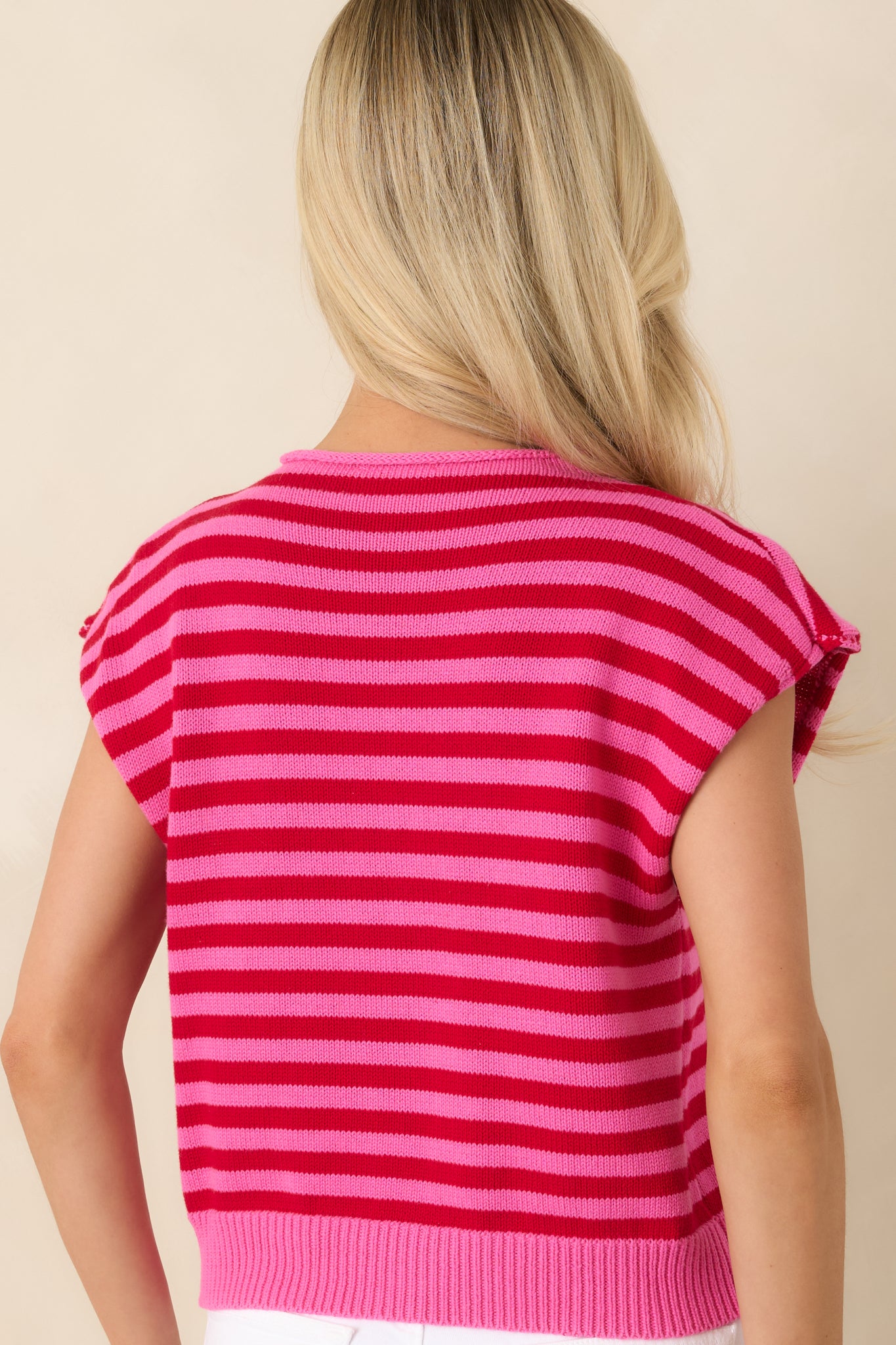 Back view of the red and pink striped knit top showcasing the relaxed cap sleeve silhouette.