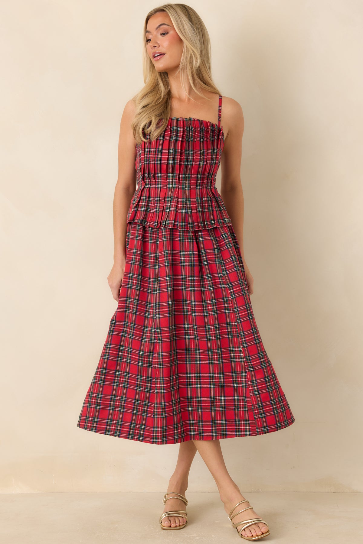 Classic red plaid dress featuring a fitted bodice, adjustable shoulder straps, and a waist peplum.