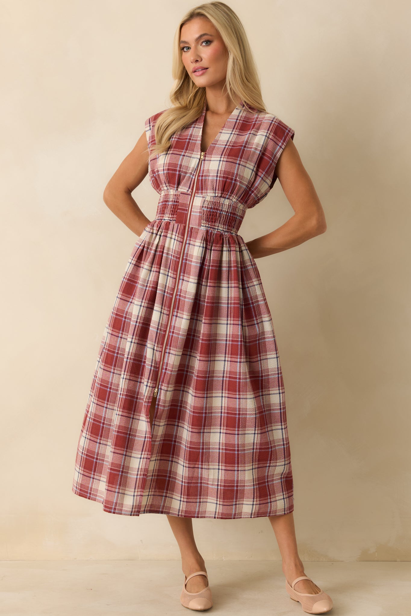Full-length red plaid dress showcasing capped sleeves, front slit, and zip-front closure with functional pockets.
