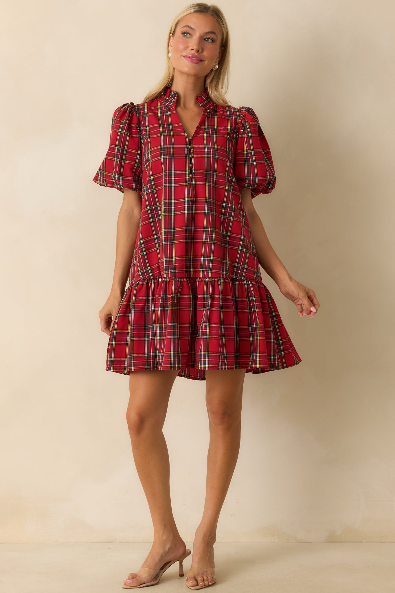 Relaxed-fit red plaid mini dress with short puff sleeves, fully lined construction, and ruffled hem detail.