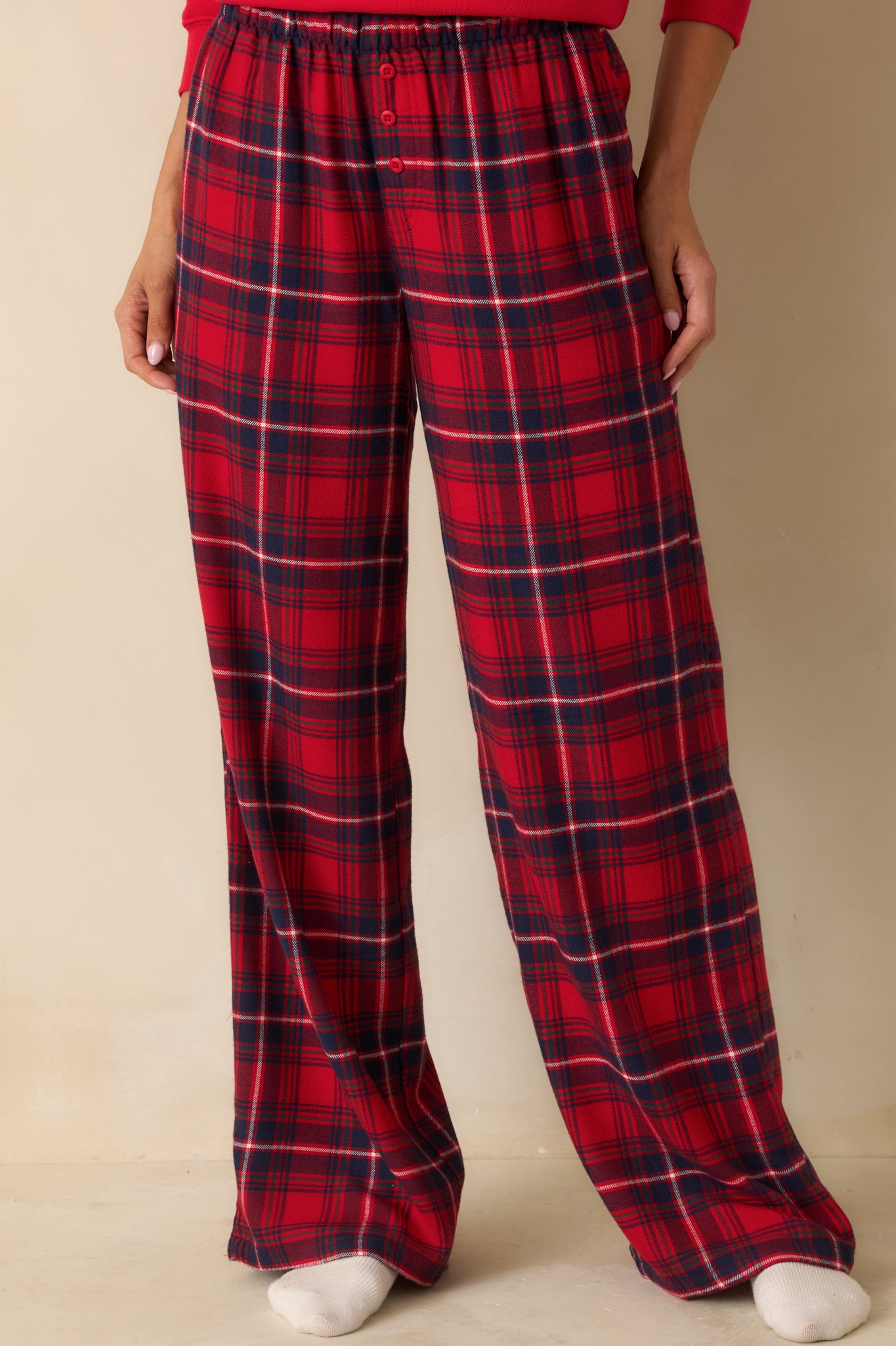 Red plaid pajama pants cropped mid-leg, highlighting straight-leg silhouette and soft flannel fabric.