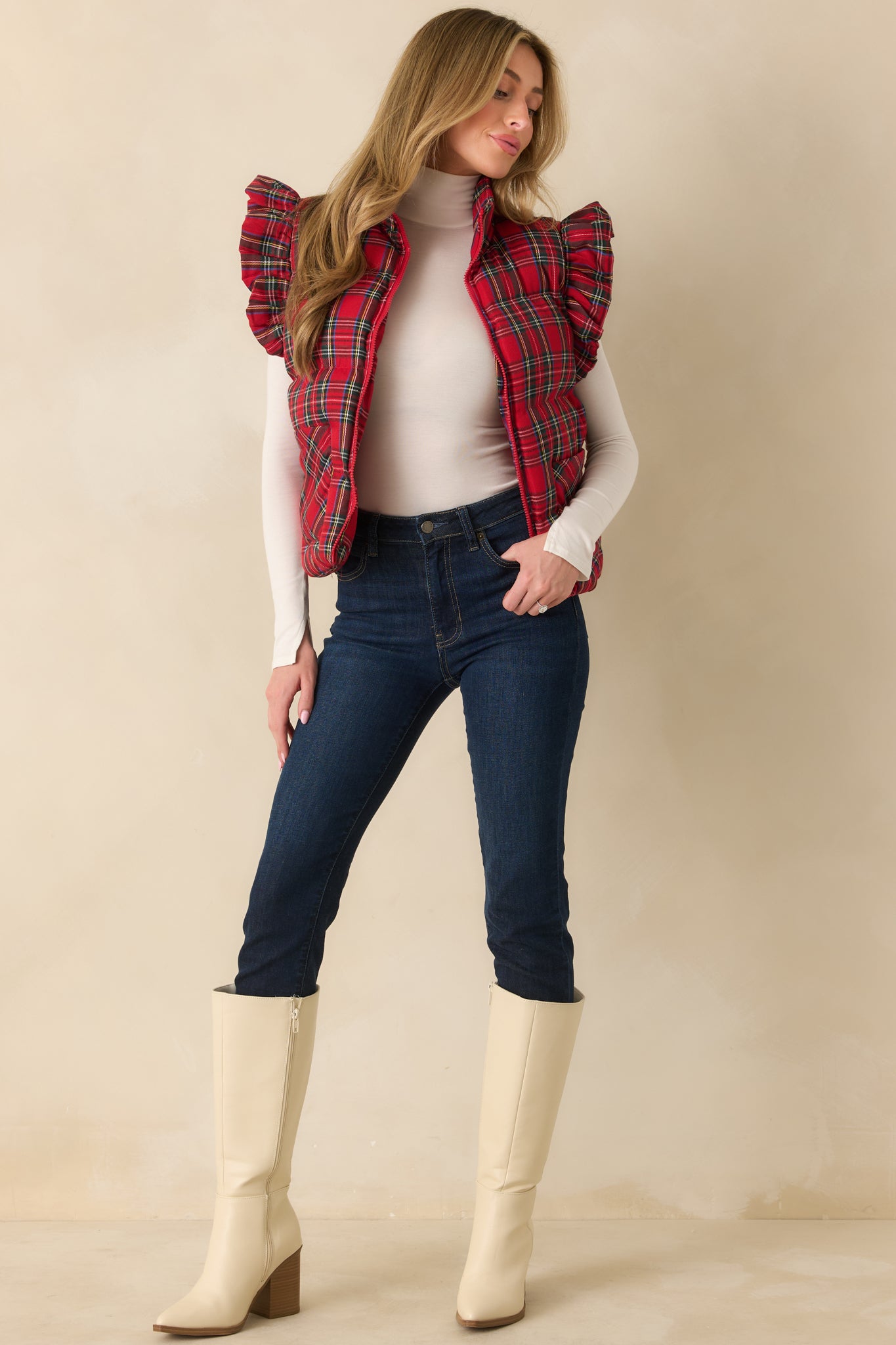 Red plaid puffer vest displaying its cozy quilted texture and side pockets.