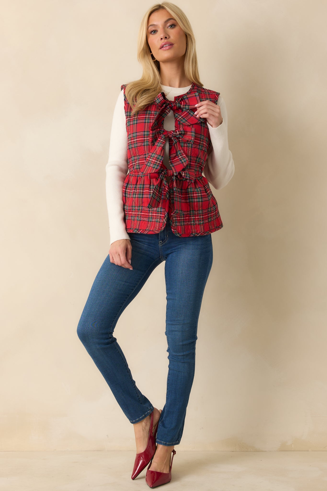 Red plaid quilted vest with a sleeveless design, peplum-style hem, and three front self-tie bow closures.
