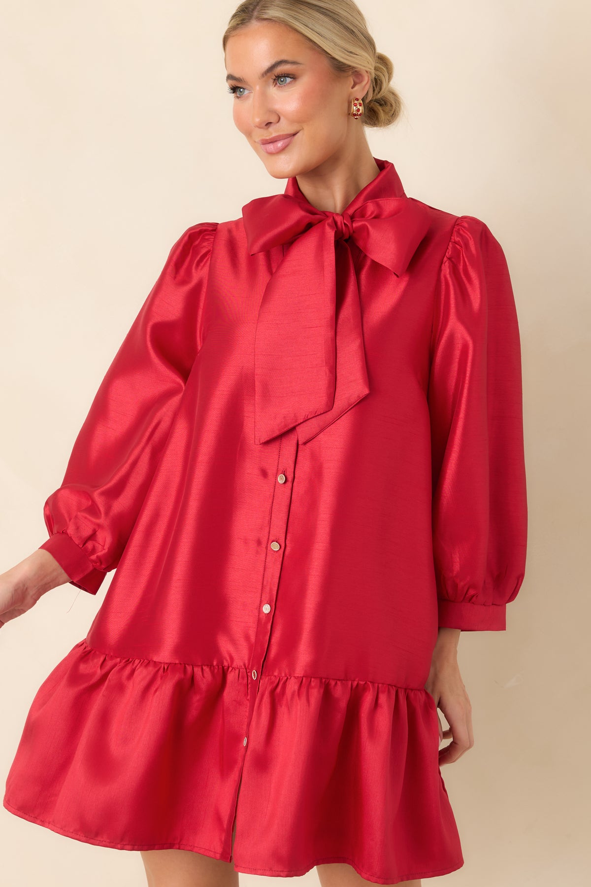 Red dress with three-quarter puff sleeves gathered into fitted banded cuffs and a softly shaped silhouette.