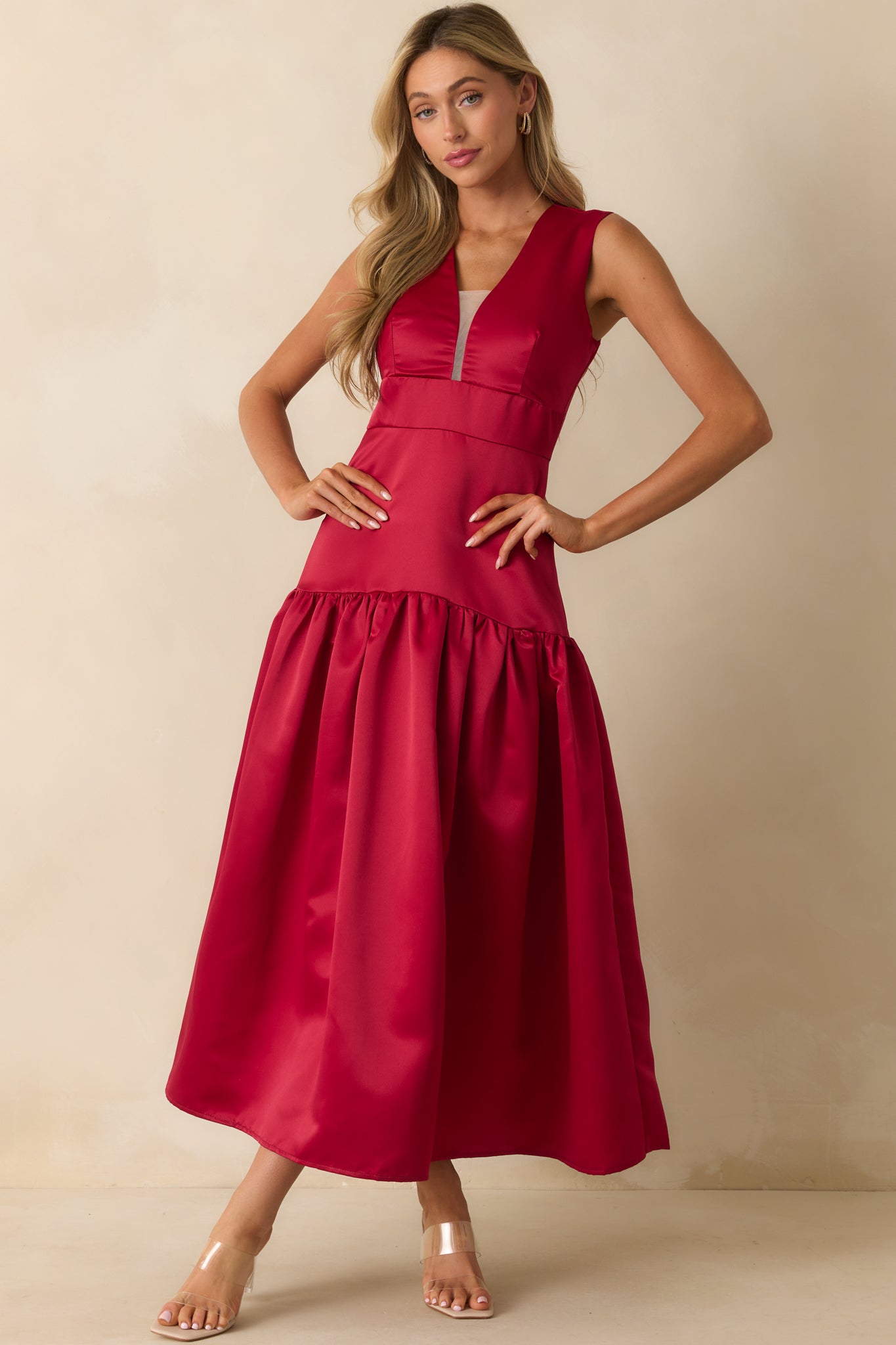 Satin red dress highlighting the floor-length drape and structured bodice.