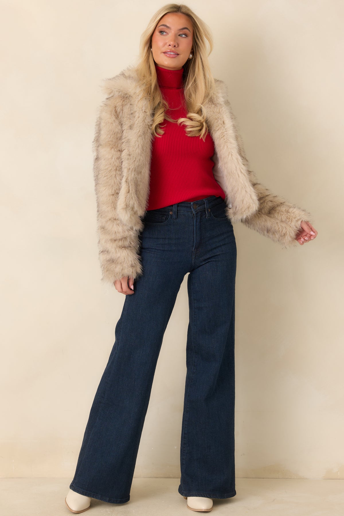 Vibrant red sleeveless sweater with a tall folded turtleneck and a smooth, body-skimming fit.