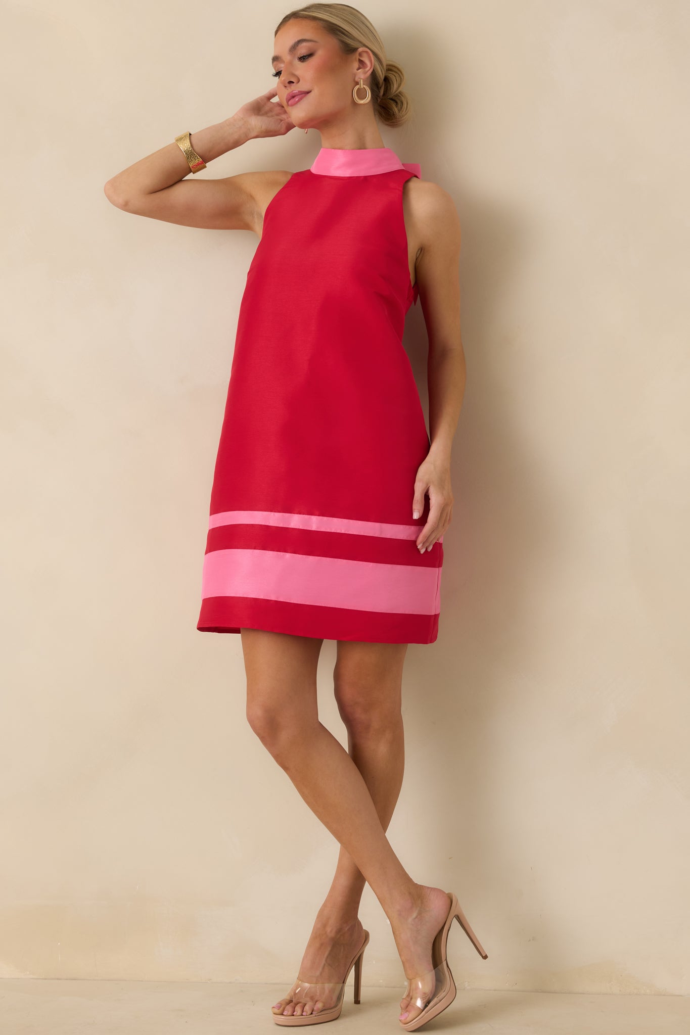 Red sleeveless mini dress with a high neckline, clean shift silhouette, and structured woven fabric.