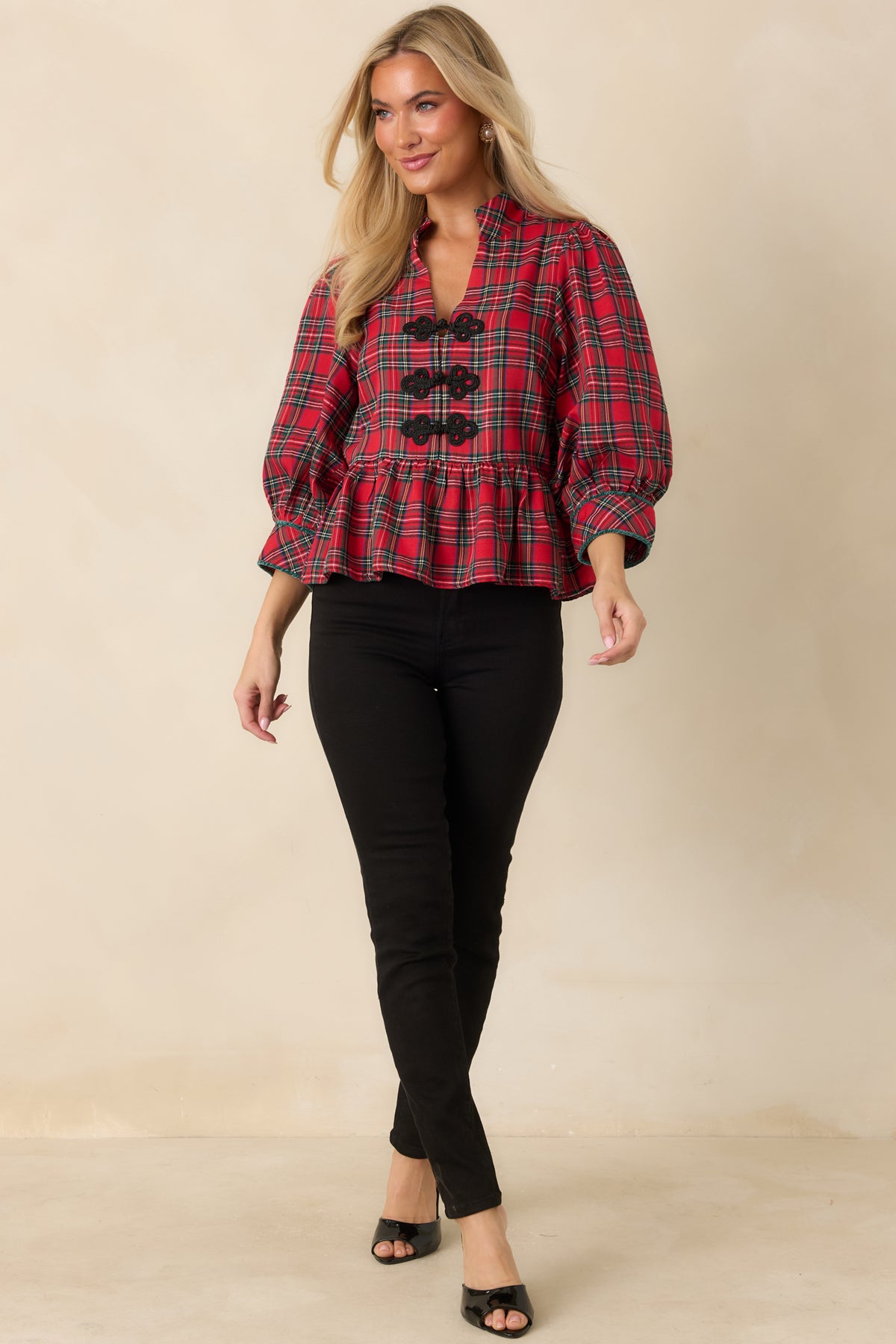 Red and green tartan top accented with black braided closures, red-piped sleeve cuffs, and a flared peplum hem.