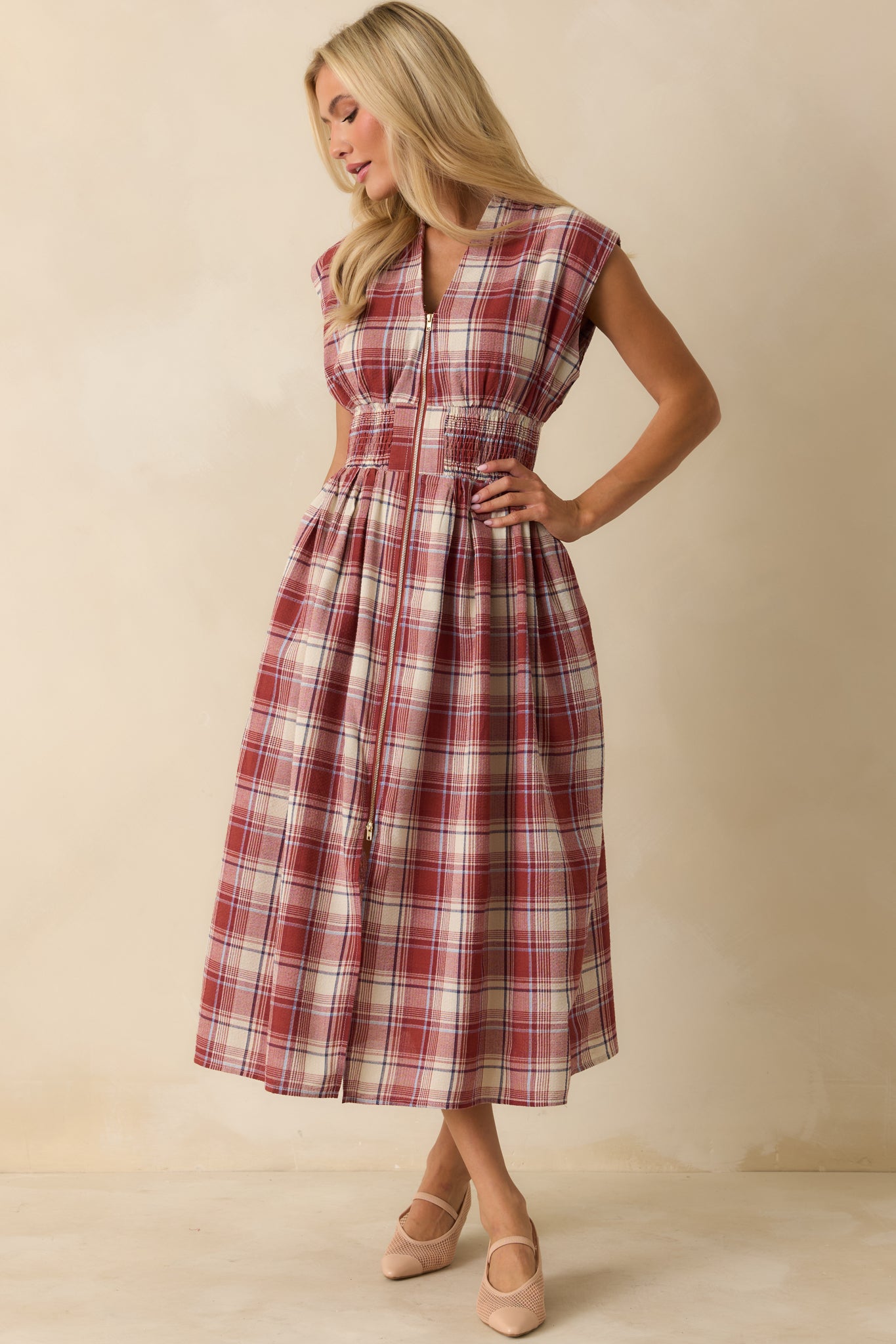 Red tartan midi dress with V-neckline, padded shoulders, and fitted smocked waist for structured yet comfortable wear.