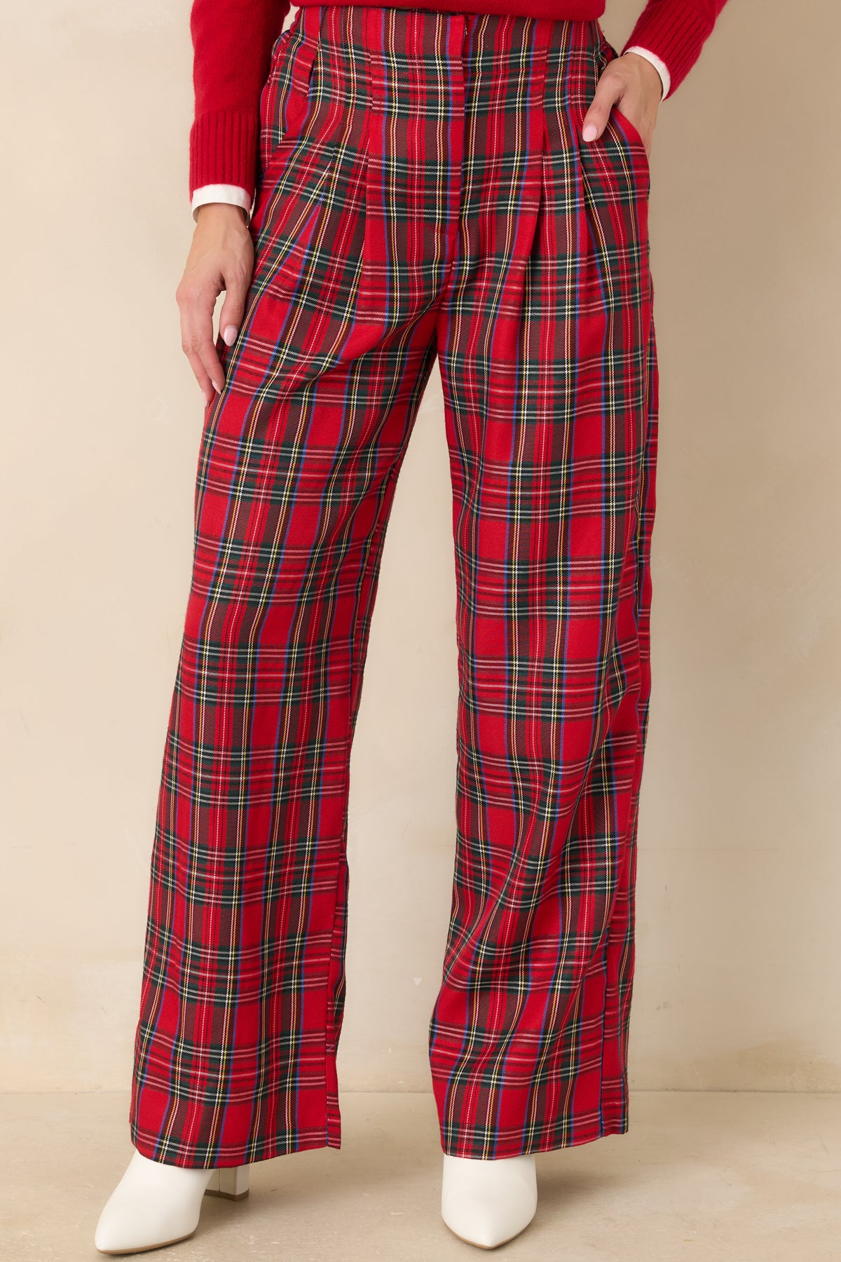 Red tartan plaid pants with front pleats flowing into full, wide-cut legs.