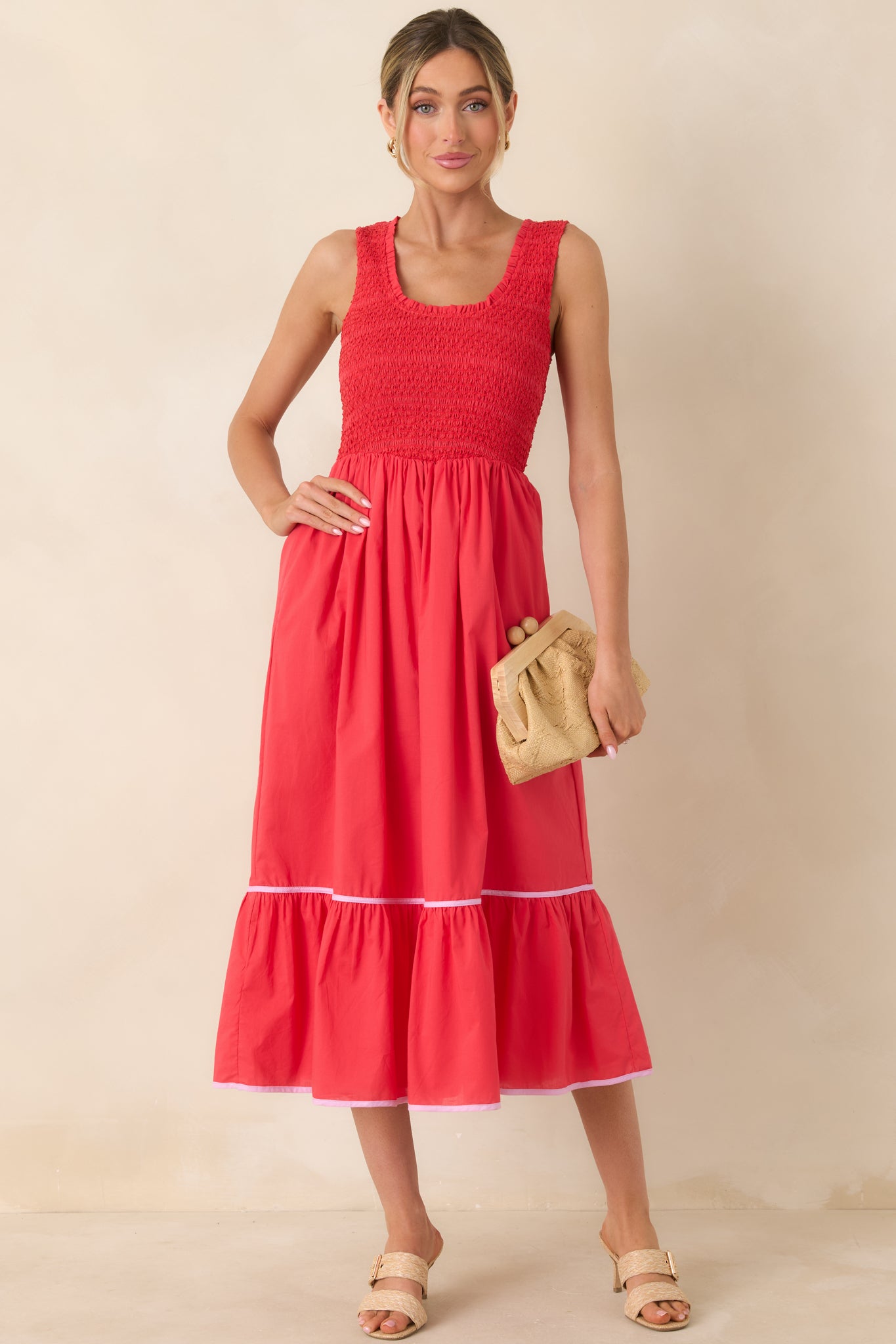 Red textured cotton midi dress with a smocked bodice, sleeveless scoop neckline, and flowing tiered skirt.