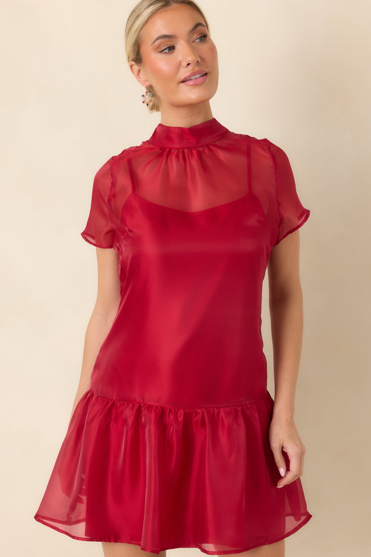 Red mini dress showcasing the translucent fabric across the neckline and sleeves with an airy layered finish.
