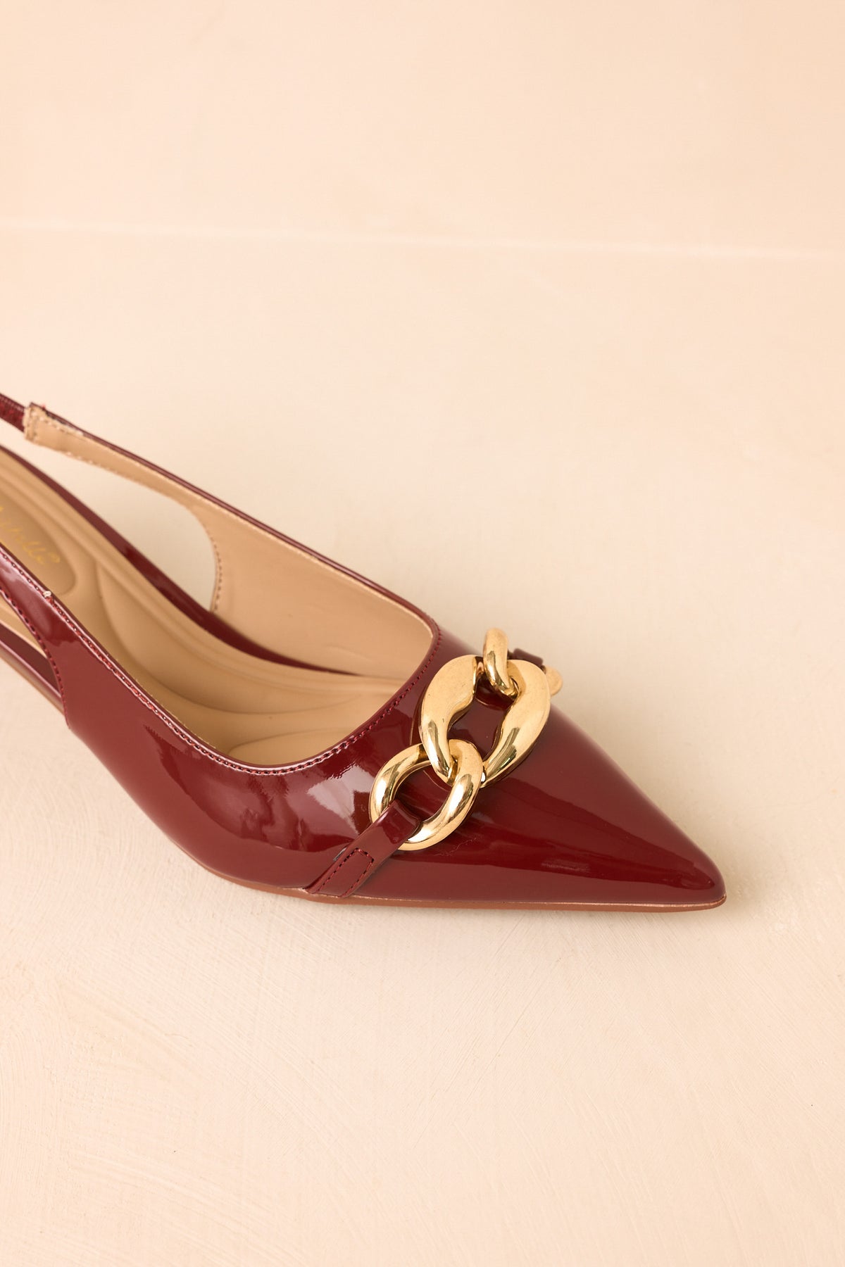 Reddish-brown slingback heels featuring a low kitten heel and polished finish.

