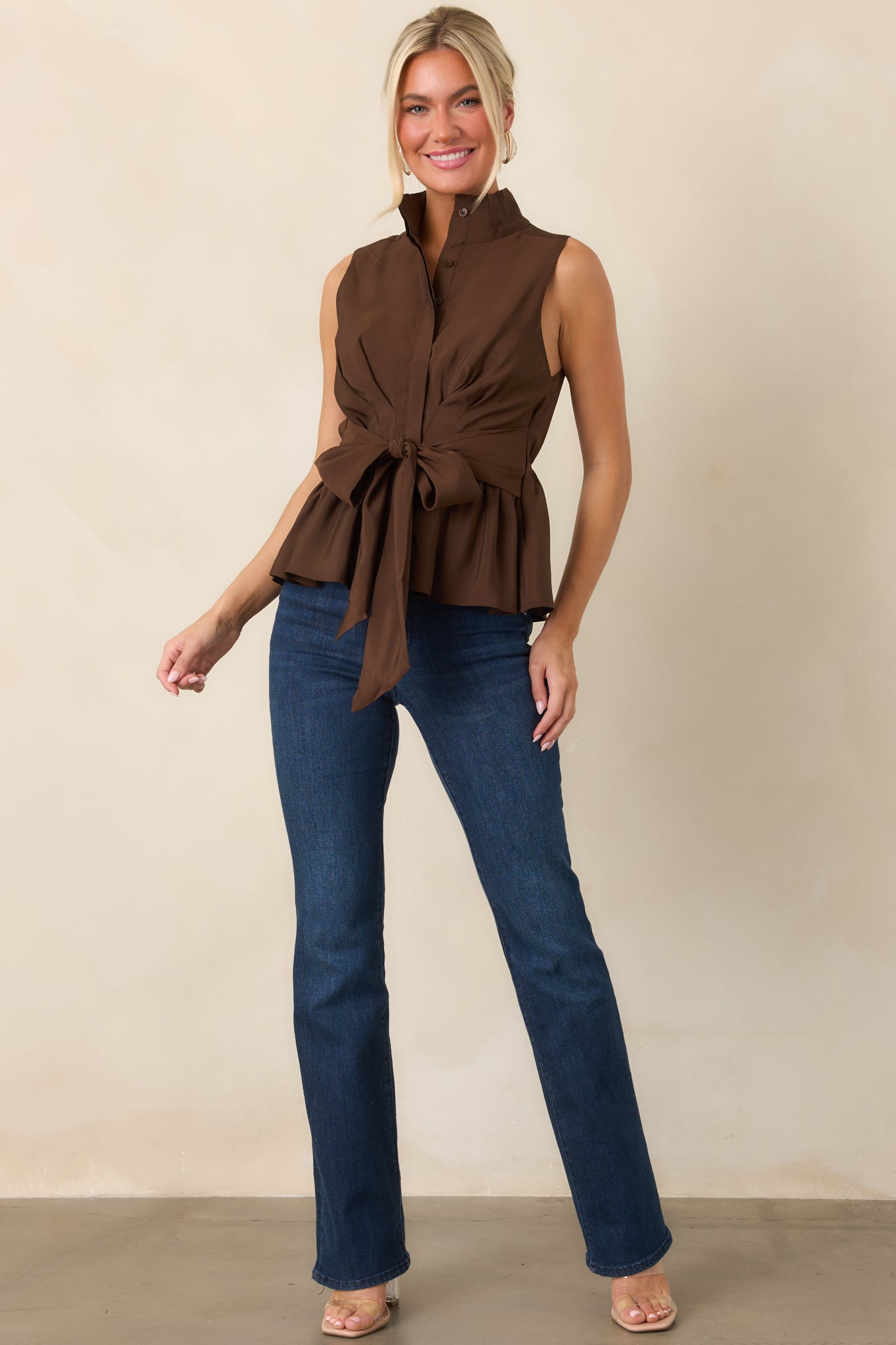 Refined fabric-blend top with a stand collar, partial buttons, adjustable-looking front tie, and softly flared peplum shape.
