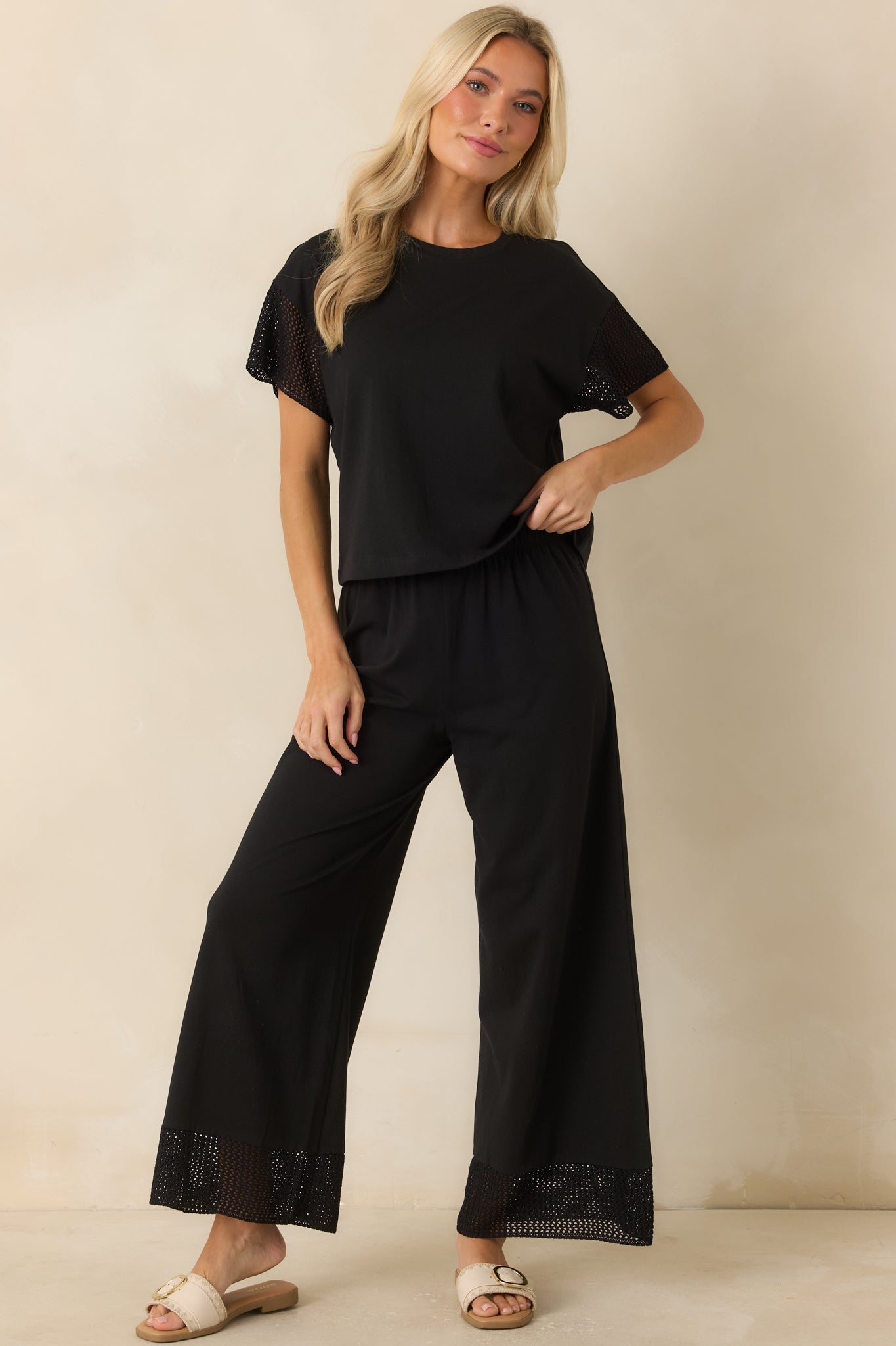 Relaxed black top with a cropped length, crew neckline, and crochet detailing along the short sleeves for added texture.