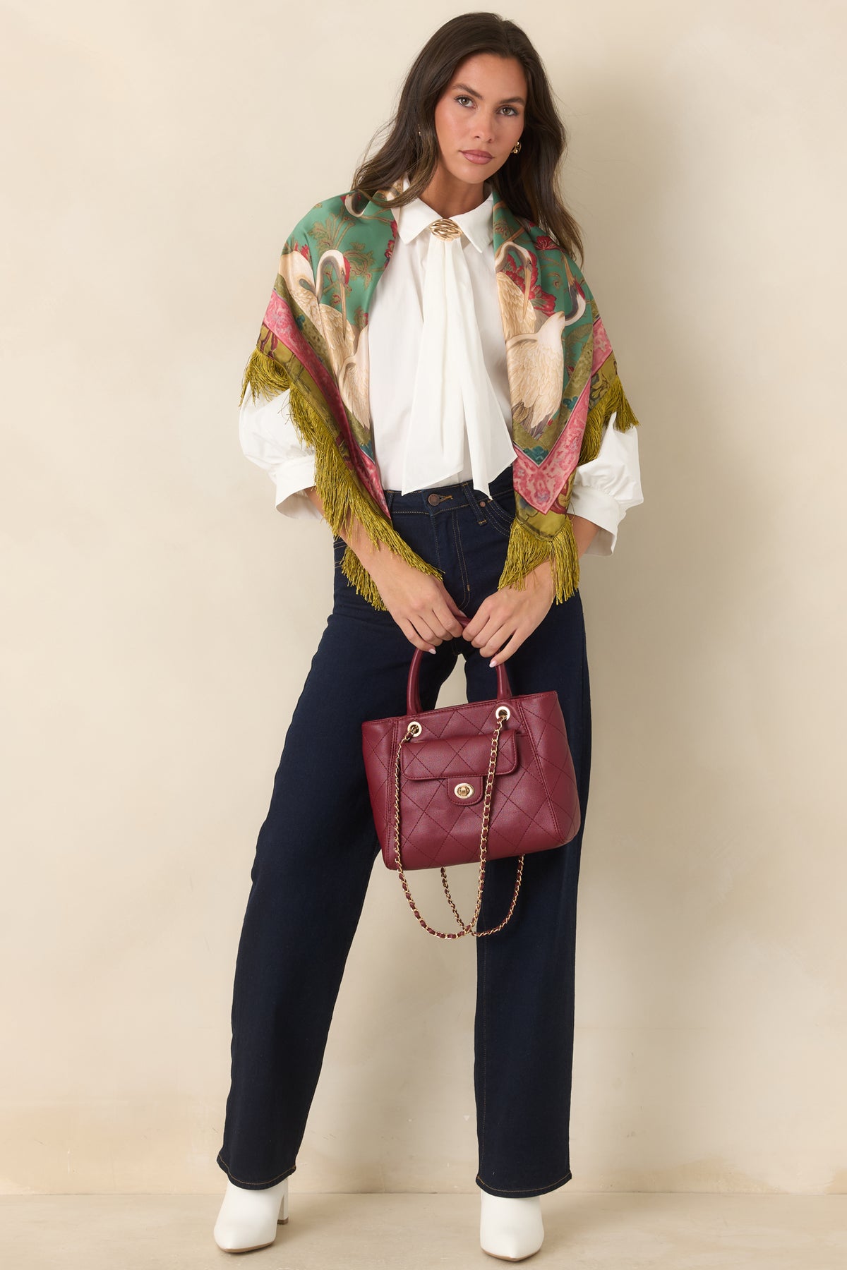 Relaxed blouse featuring gathered neck ties beneath a sculptural gold-tone accent and softly gathered shoulders.
