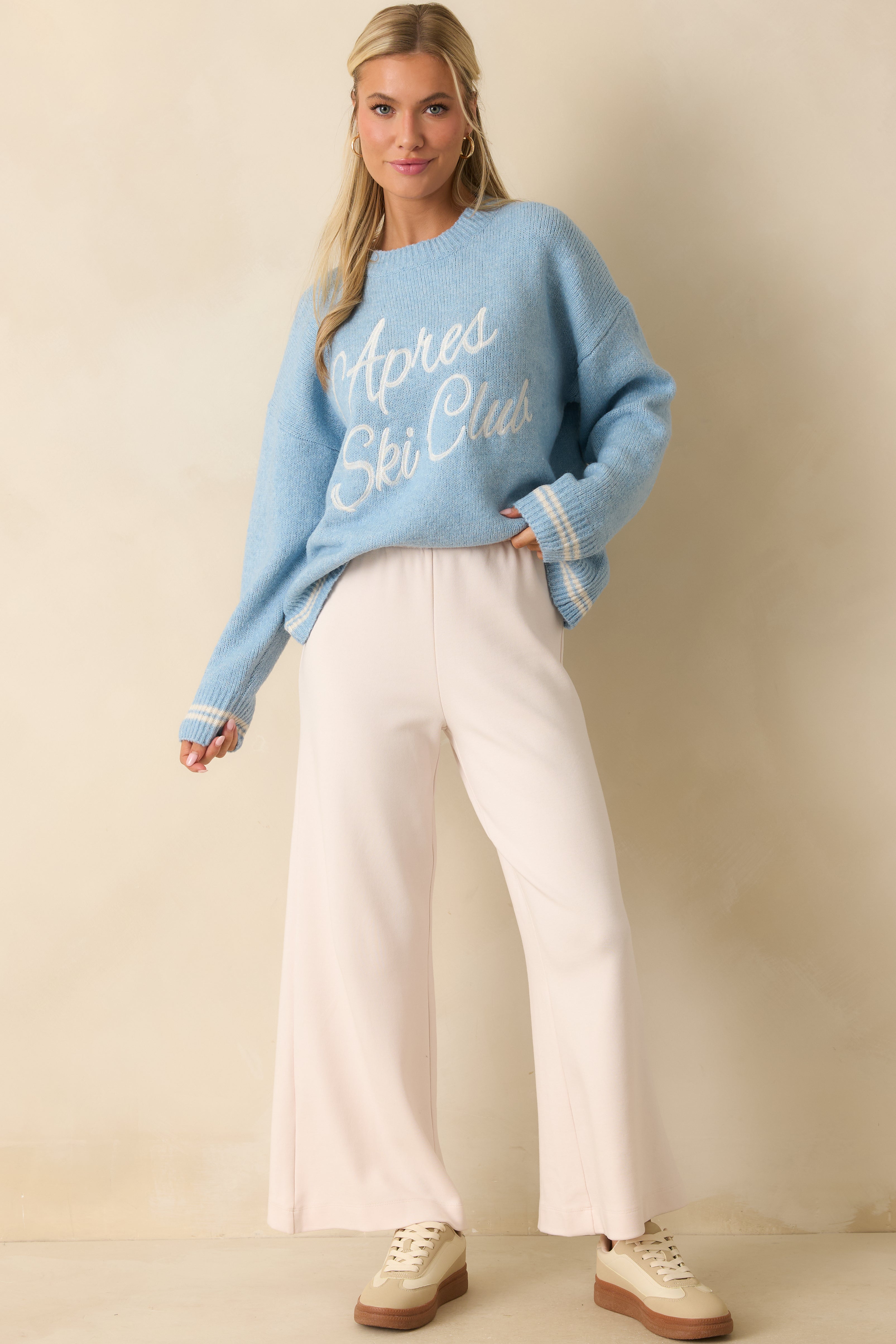 Relaxed powder blue crewneck sweater with ribbed cuffs and hem accented with subtle white stripes