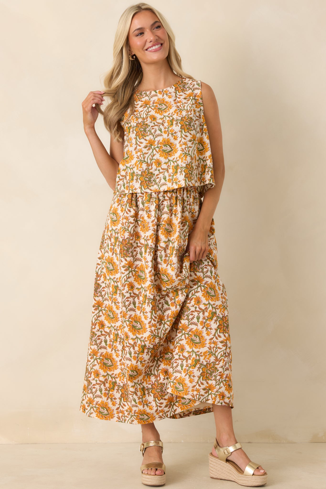 Front view highlighting the relaxed, slightly boxy silhouette and intricate marigold, olive, and tan floral print of the sleeveless top.
