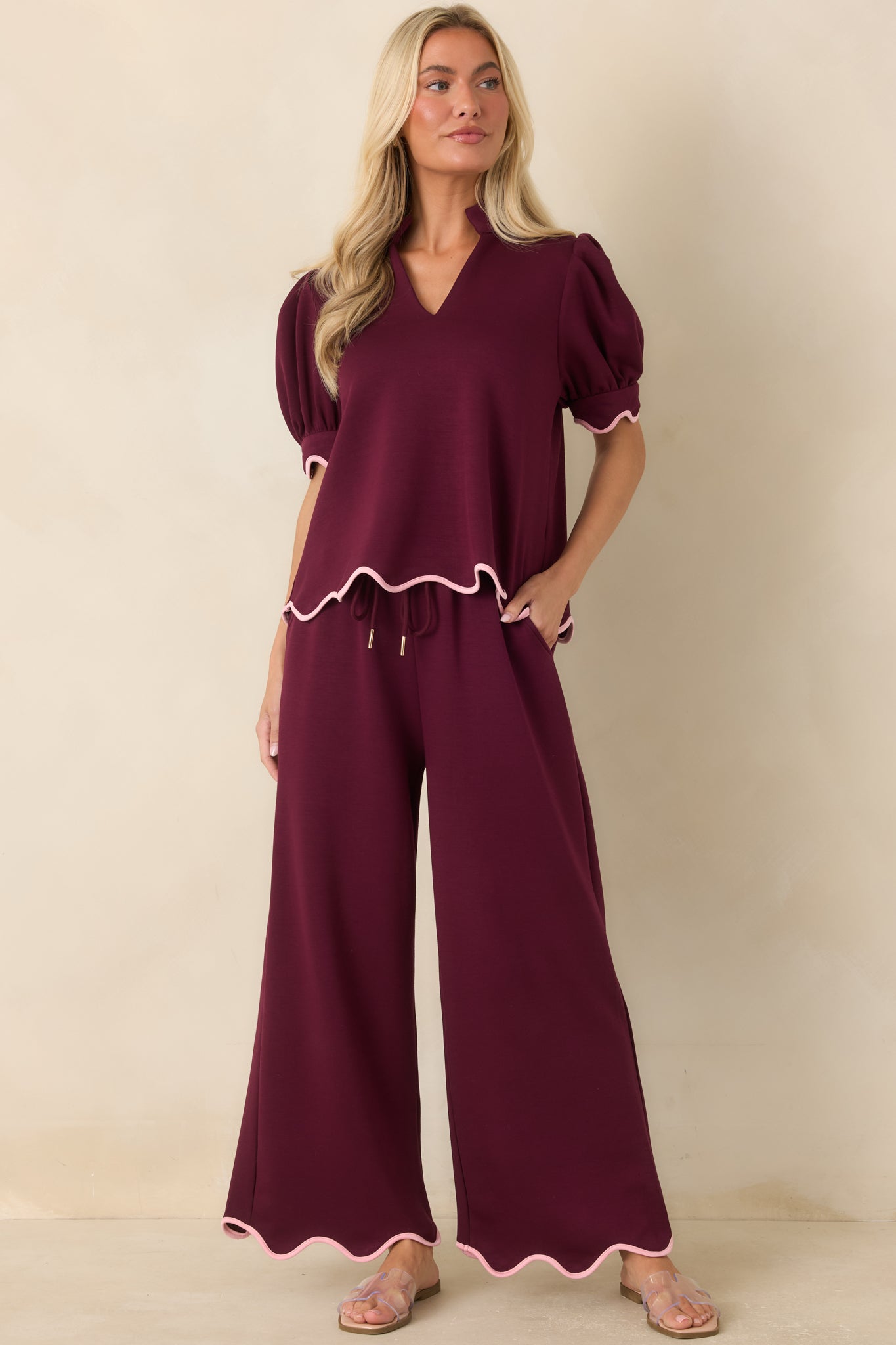 Relaxed burgundy pants crafted from soft knit fabric, finished with a drawstring waist and elegant scalloped accents for a polished look.