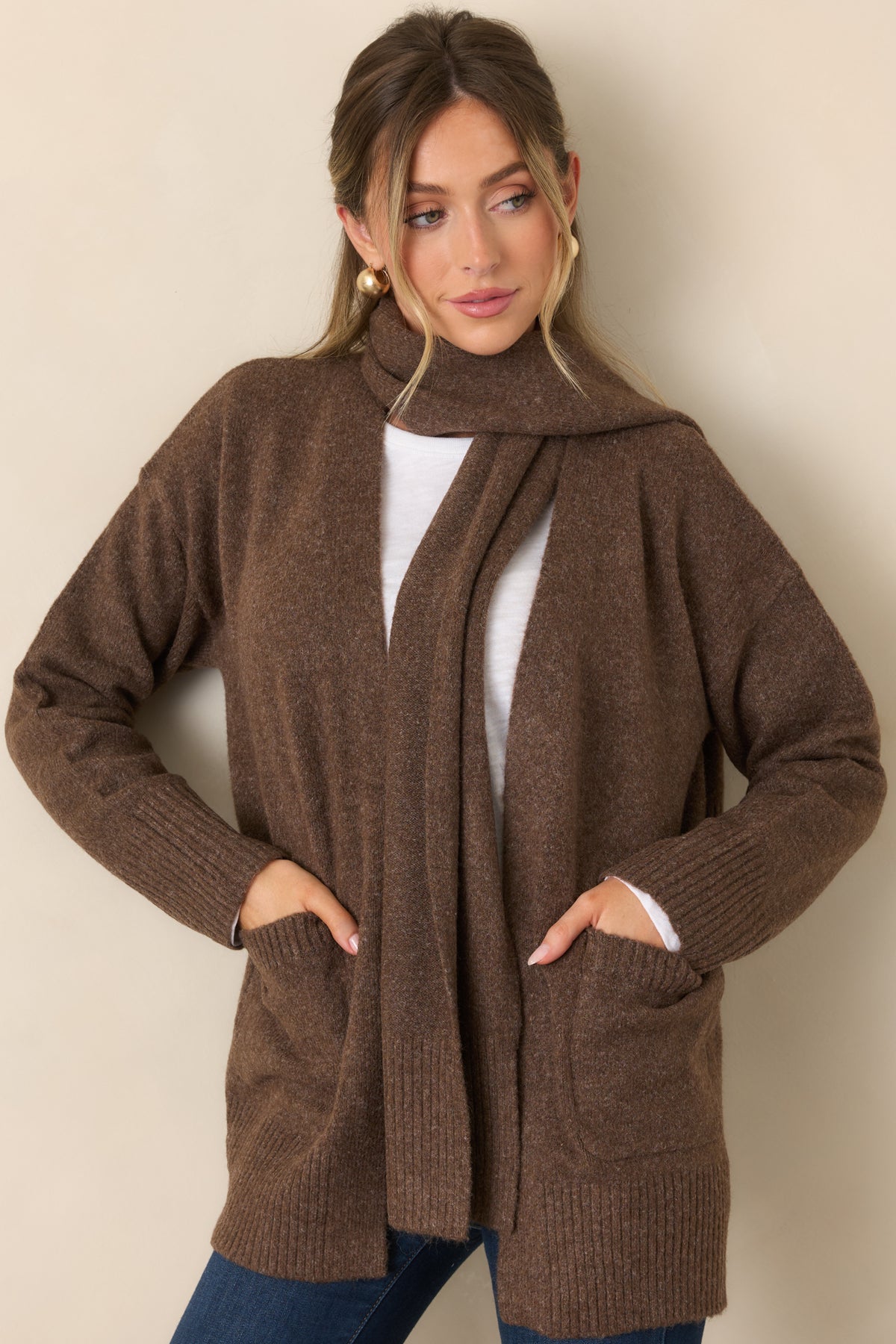 Relaxed cardigan showcasing its front patch pockets and neatly finished ribbed hem.