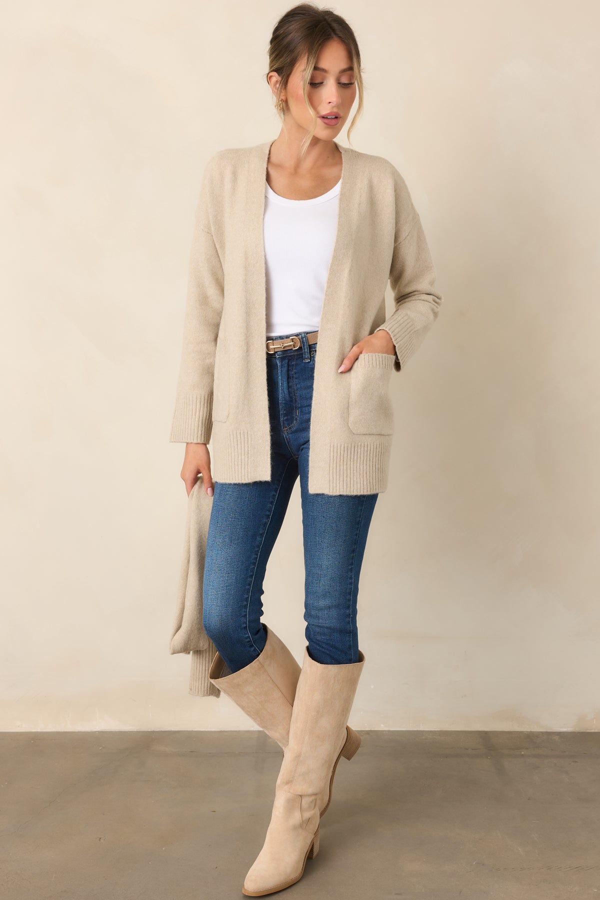 Relaxed cardigan showcases its open front, dropped shoulders, front pockets, and matching scarf accessory.