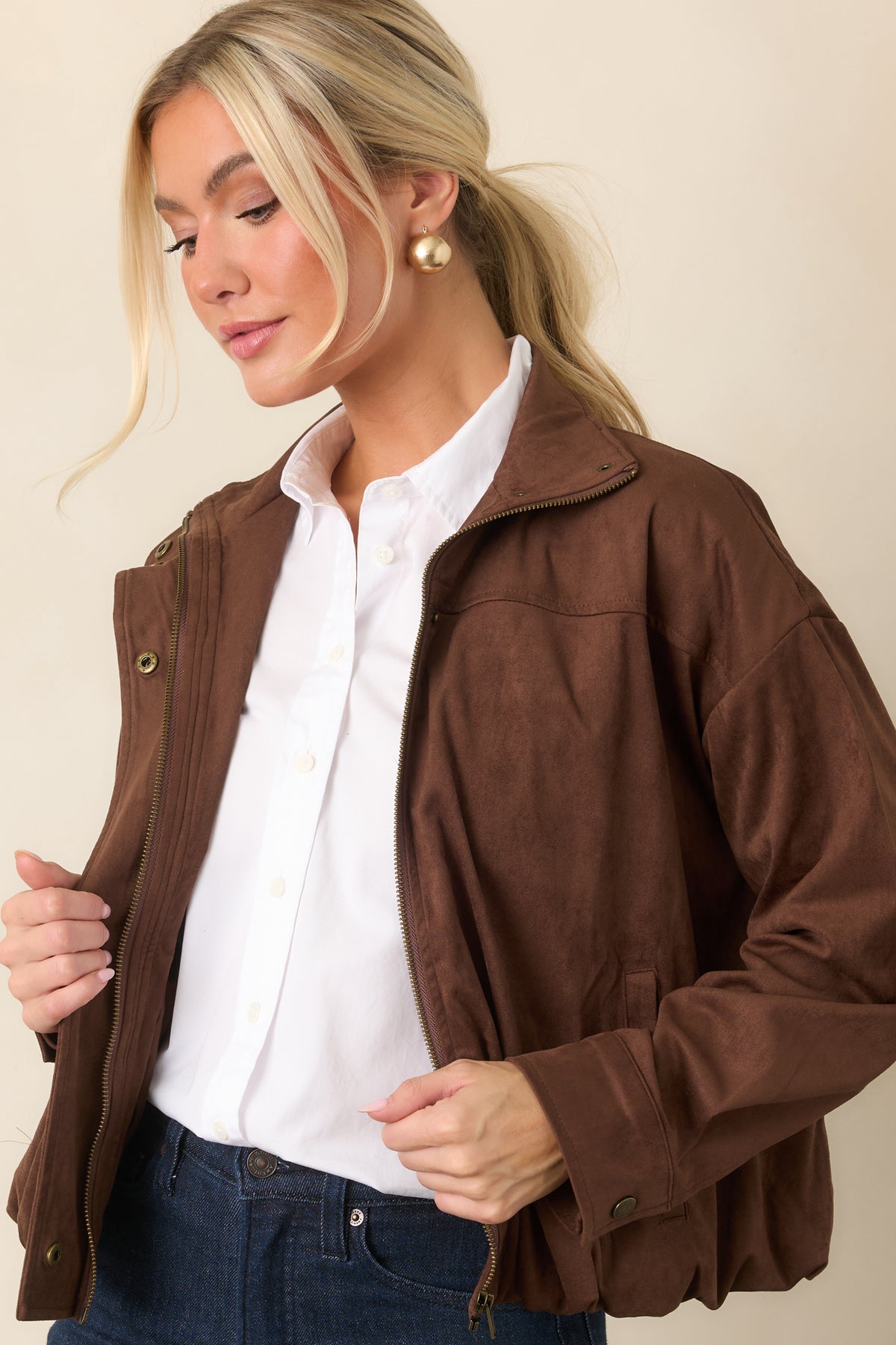 Relaxed chocolate faux suede bomber finished with snap cuffs and practical side pockets.