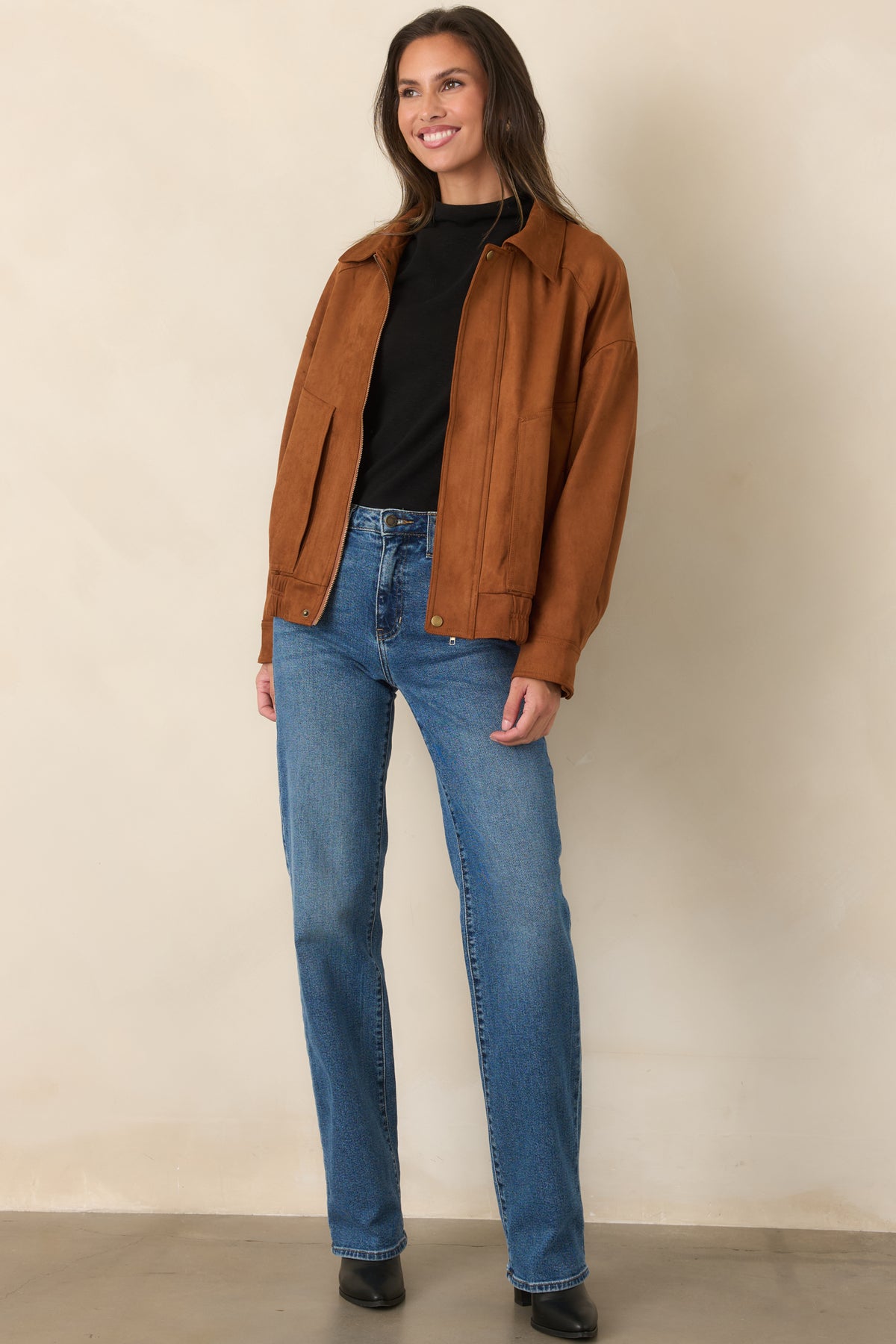 Relaxed cognac faux suede jacket featuring roomy long sleeves, snap cuffs, and an elasticized bomber hem.