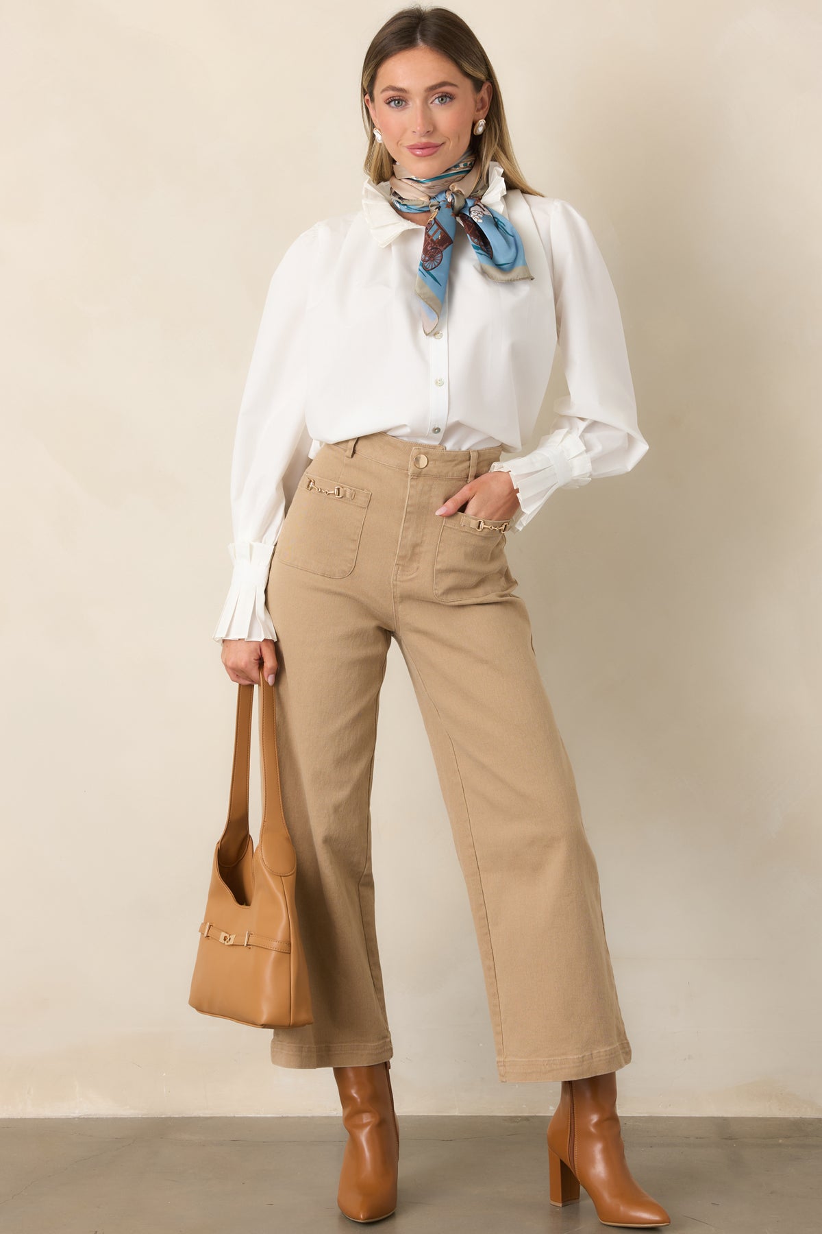 Relaxed cotton top featuring gathered shoulders, pleated neckline trim, and coordinating long sleeve cuffs.