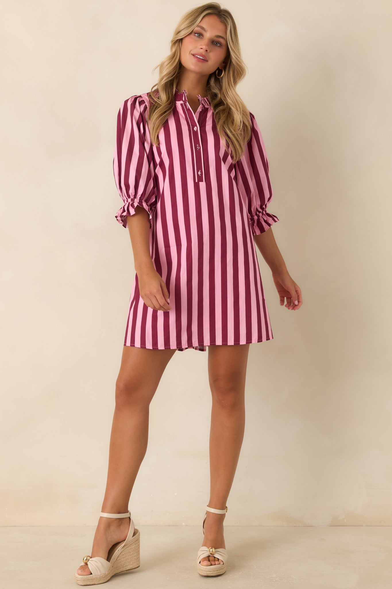 Relaxed cotton mini dress featuring pink and wine vertical stripes, puff sleeves, ruffle cuffs, and customizable waist shaping.