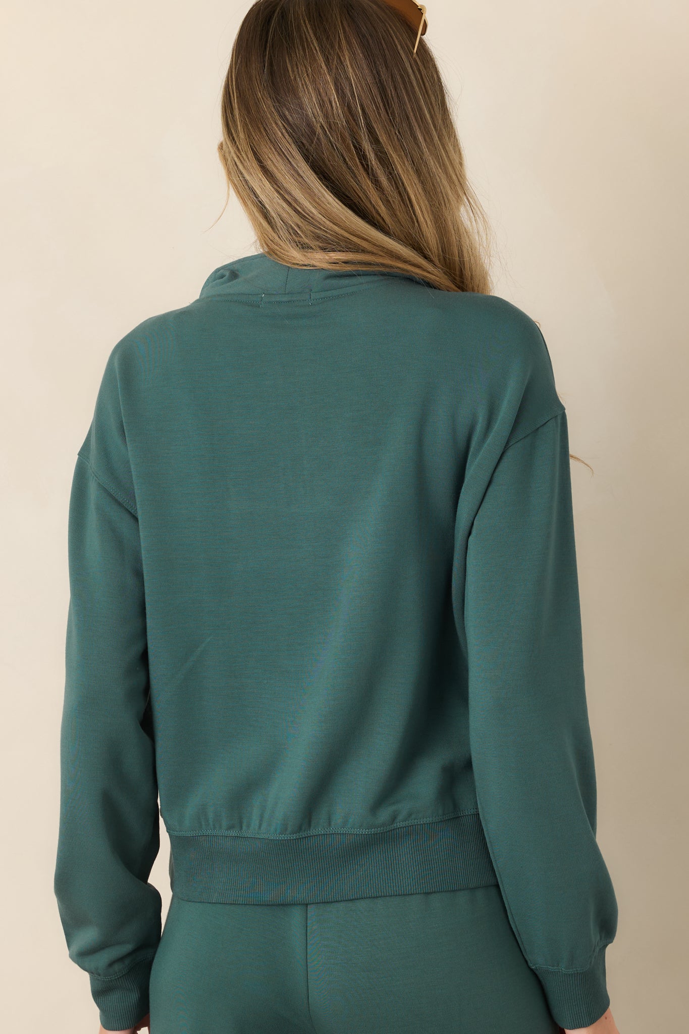 Rear view of the sweatshirt showing its dropped shoulder construction, relaxed shape, long sleeves, and ribbed hem.