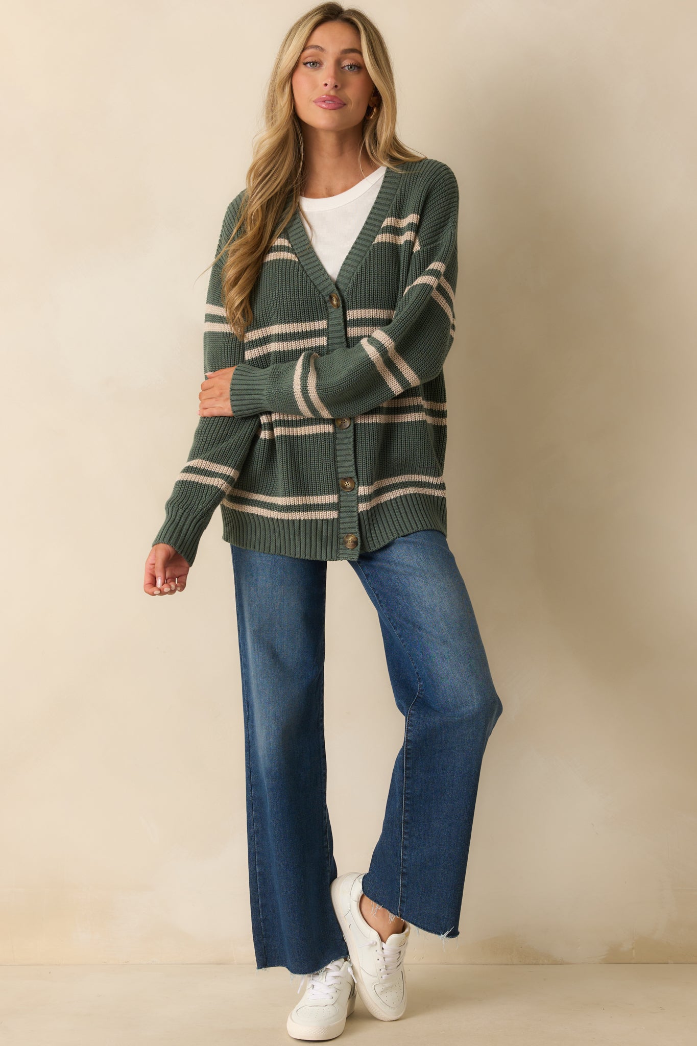 Relaxed-fit green cardigan featuring long sleeves, ribbed hems, and a striped horizontal pattern.