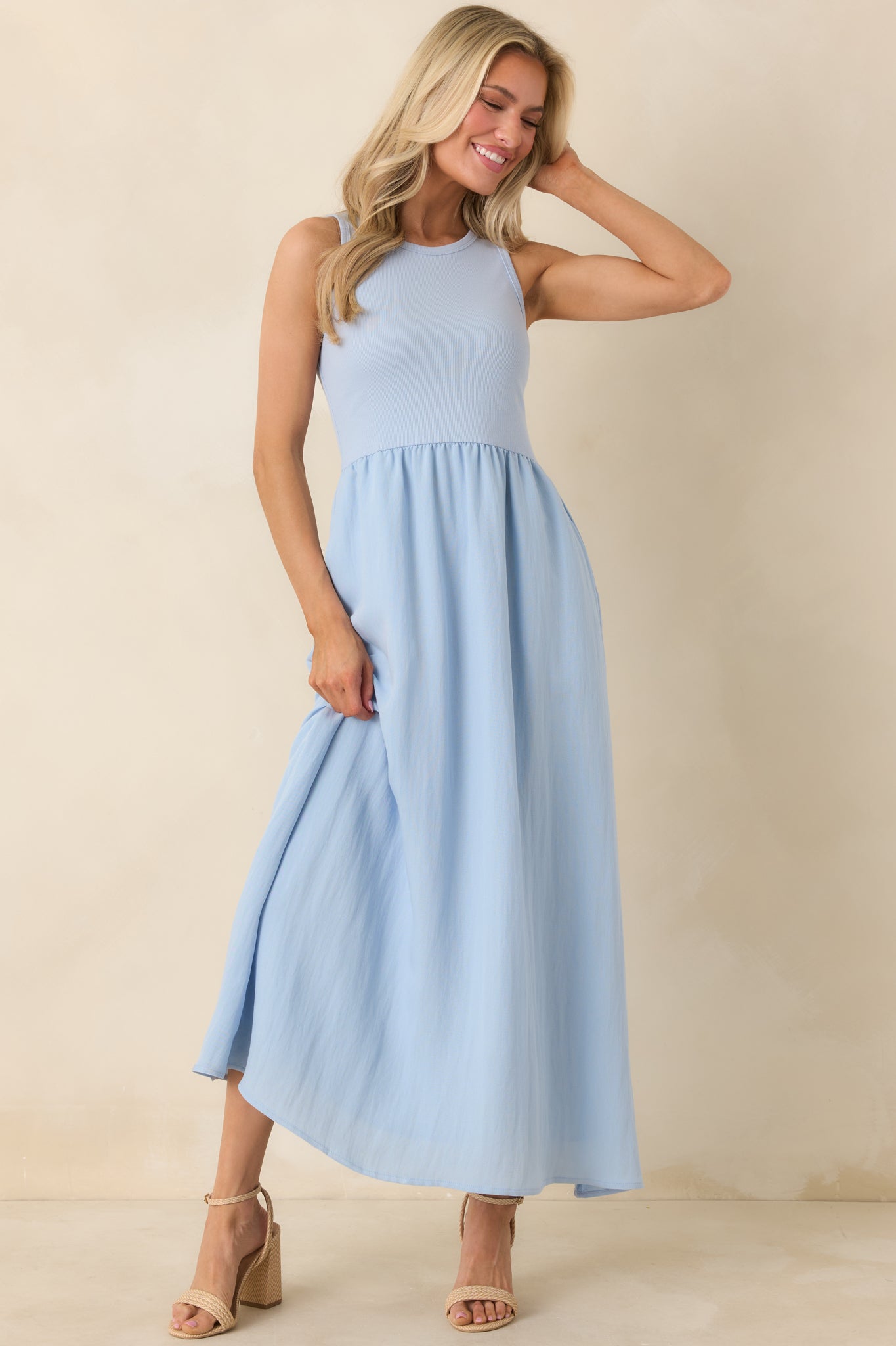 Relaxed fit light blue dress featuring a round neckline, sleeveless design, and functional side pockets.