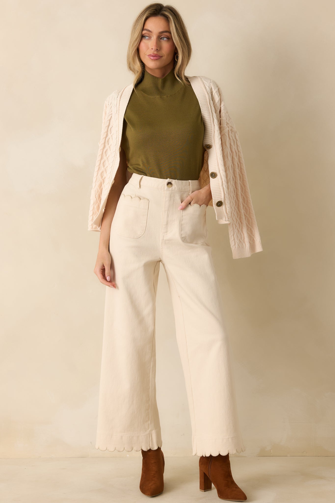 Relaxed fit of the olive green knit top with cap sleeves highlighted.