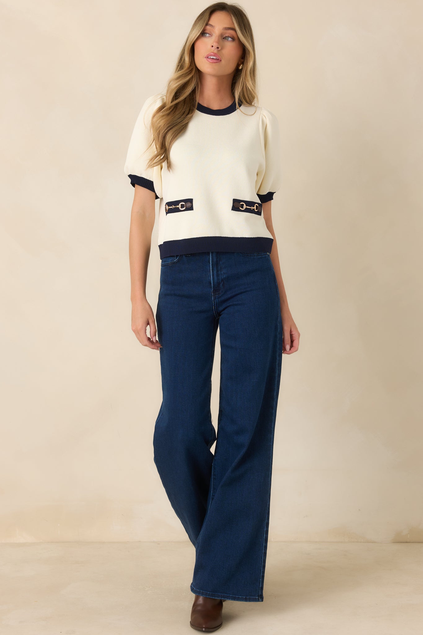 Relaxed fit top with faux front pocket accents, brown faux leather tabs, and a tailored crew neckline.
