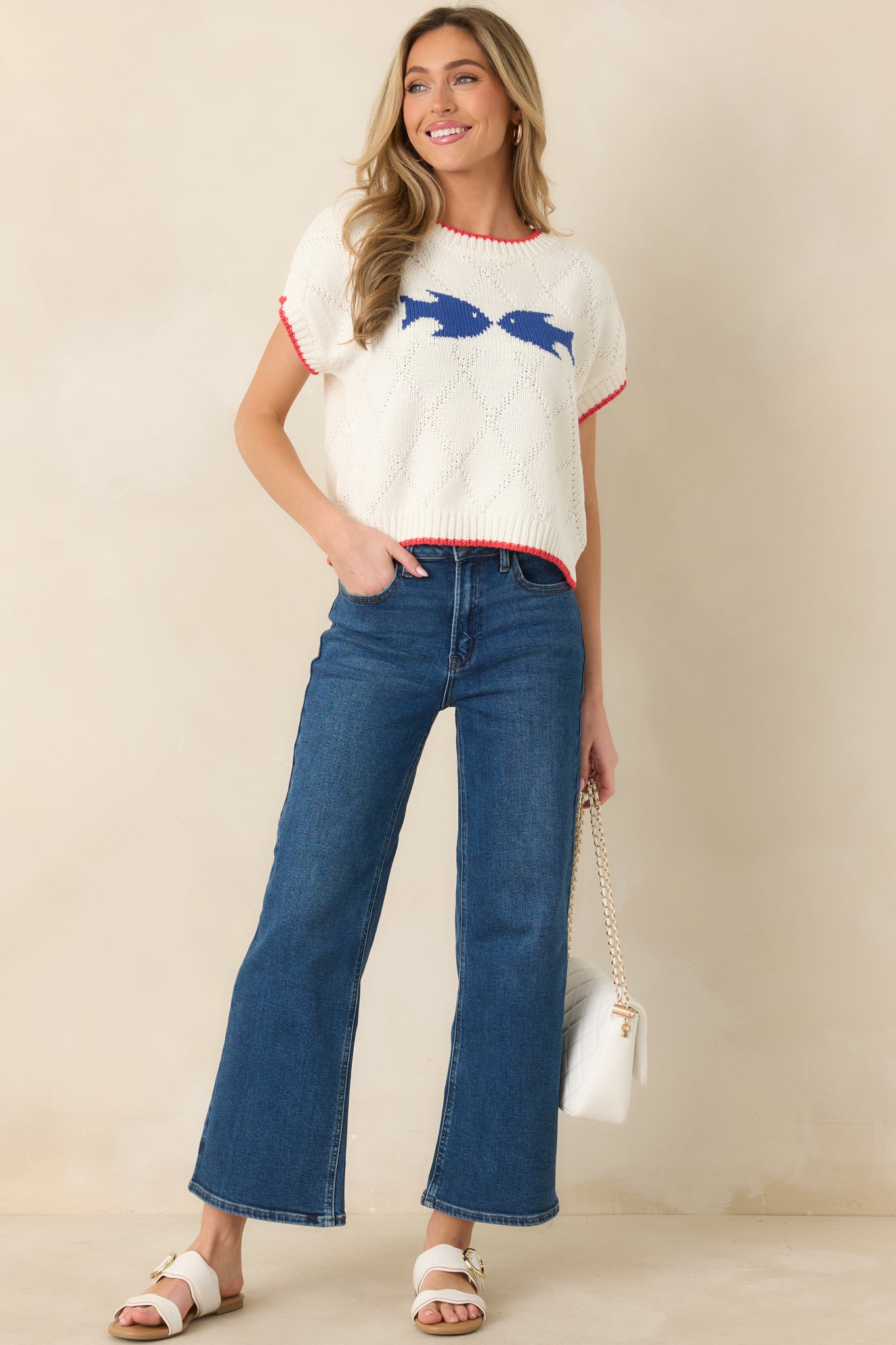 Relaxed-fit white multi-knit sweater with short sleeves, textured detailing, and playful fish graphic on the front.