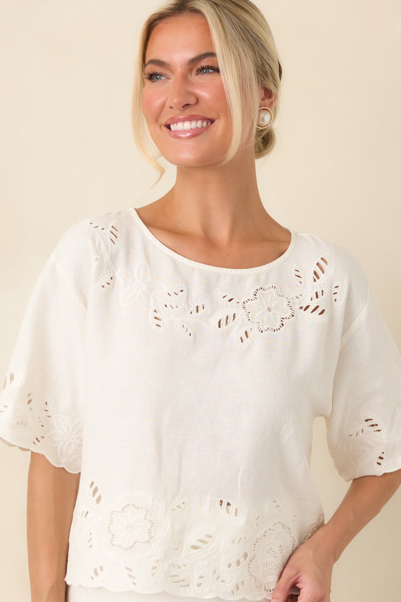 Relaxed silhouette with embroidered floral cutwork creates a light and refined look on this white top.