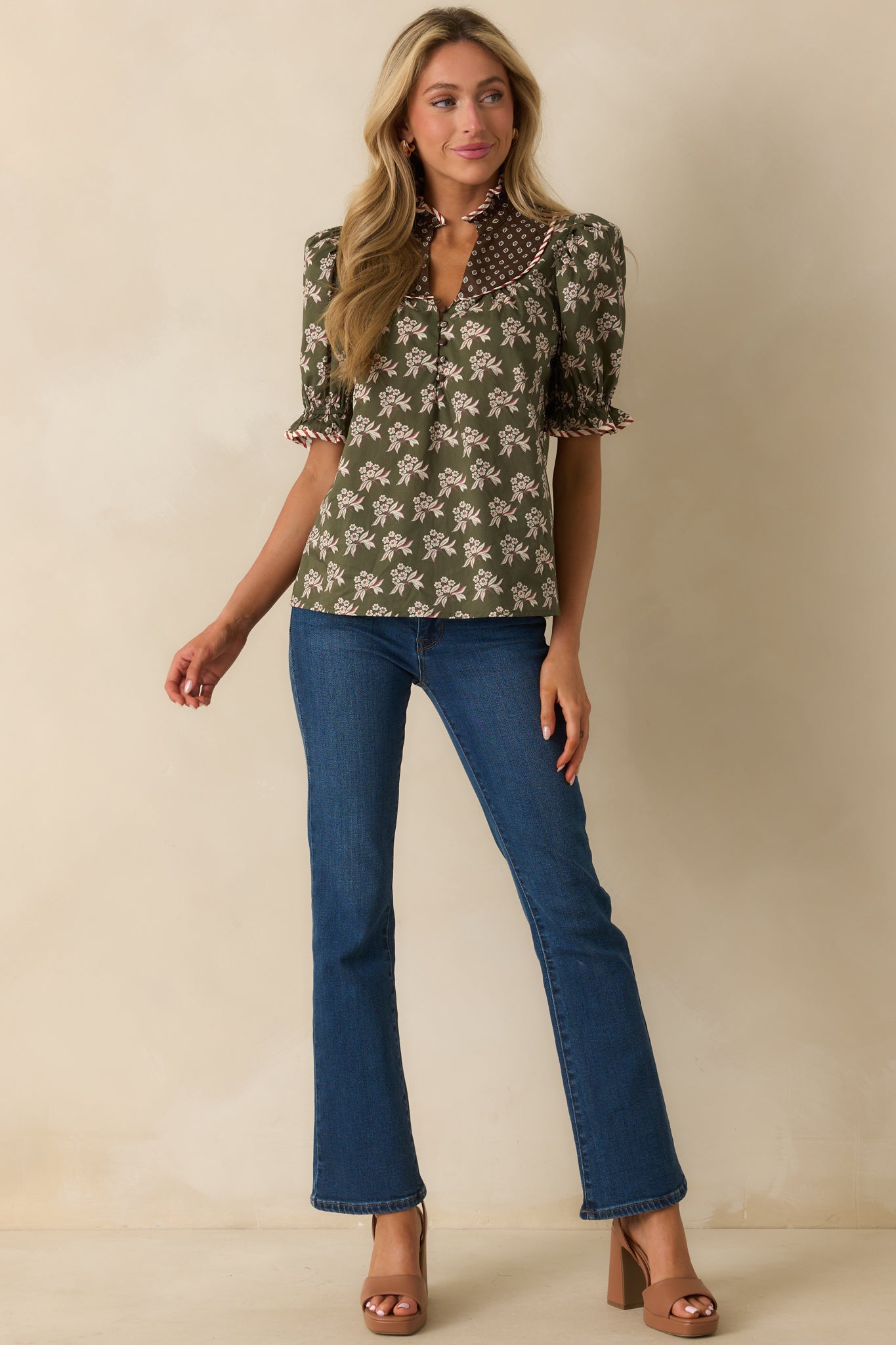 Relaxed fit floral top accented with striped piping trim and smocked sleeve cuffs.
