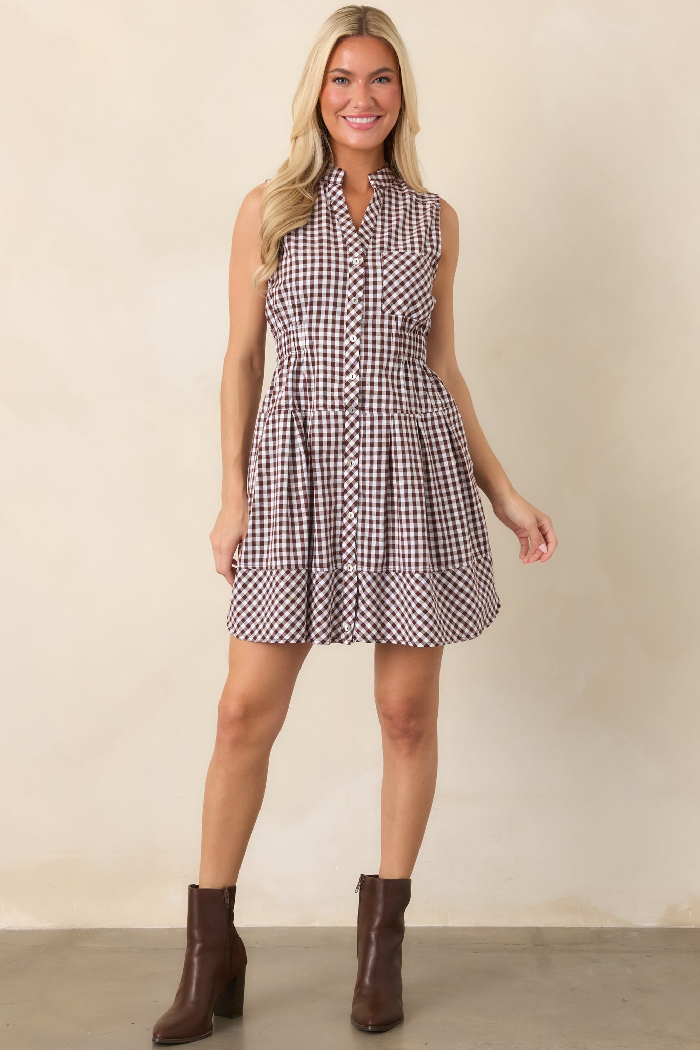 Relaxed gingham dress with a polished button-front design, defined elastic waist, short sleeves, and practical side pockets.