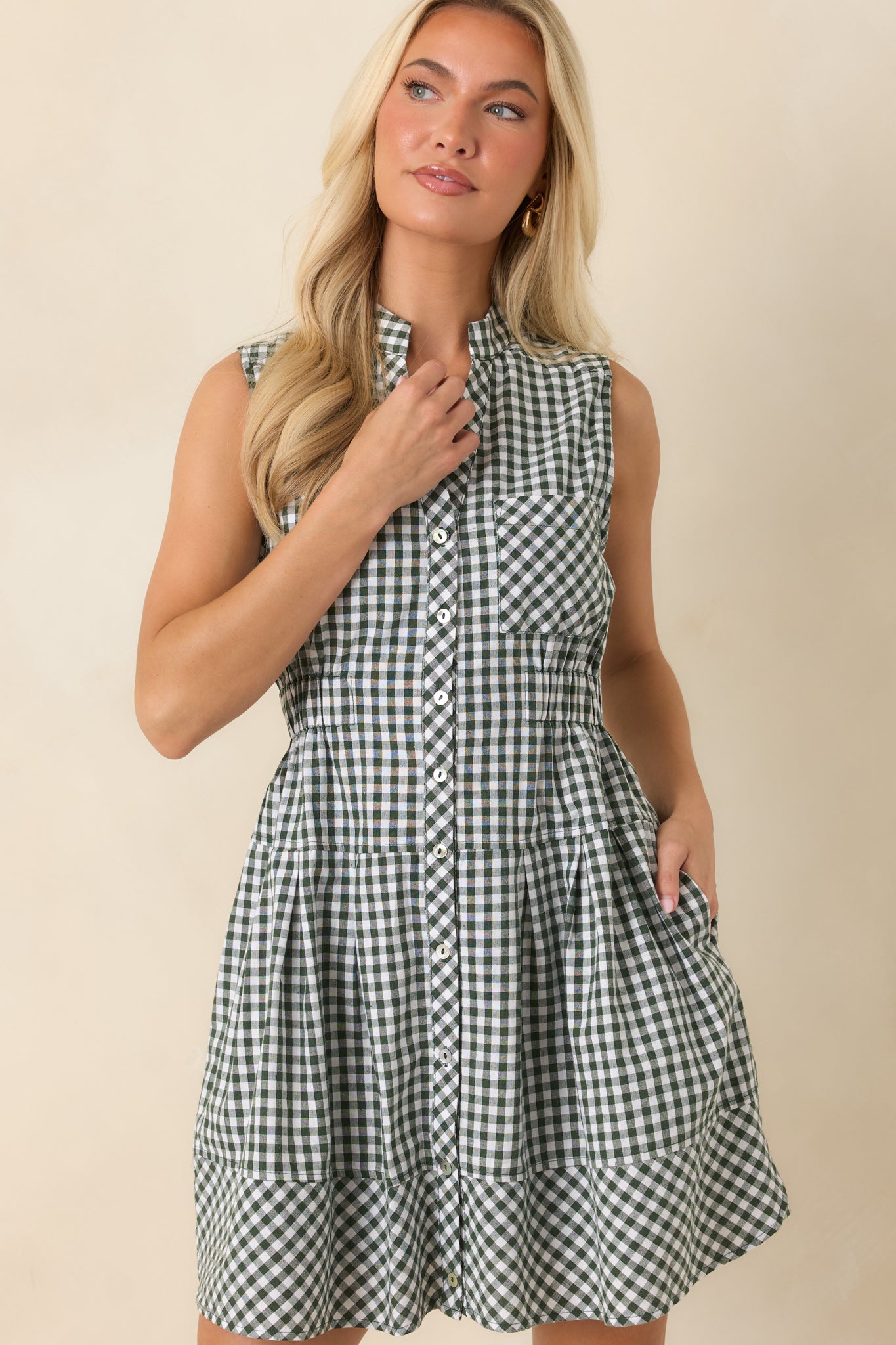 Relaxed gingham mini dress highlighting the elastic waist, button-front closure, and lightweight lined fabric.
