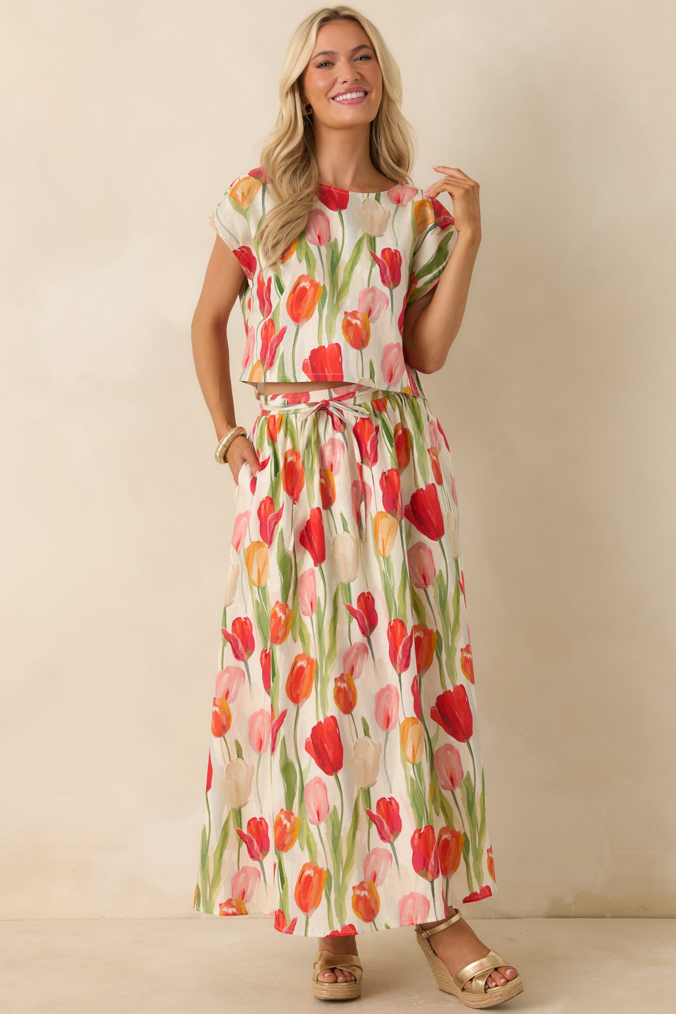 Relaxed ivory cropped top showcasing a bold red floral tulip print, soft linen blend texture, and classic round neckline.