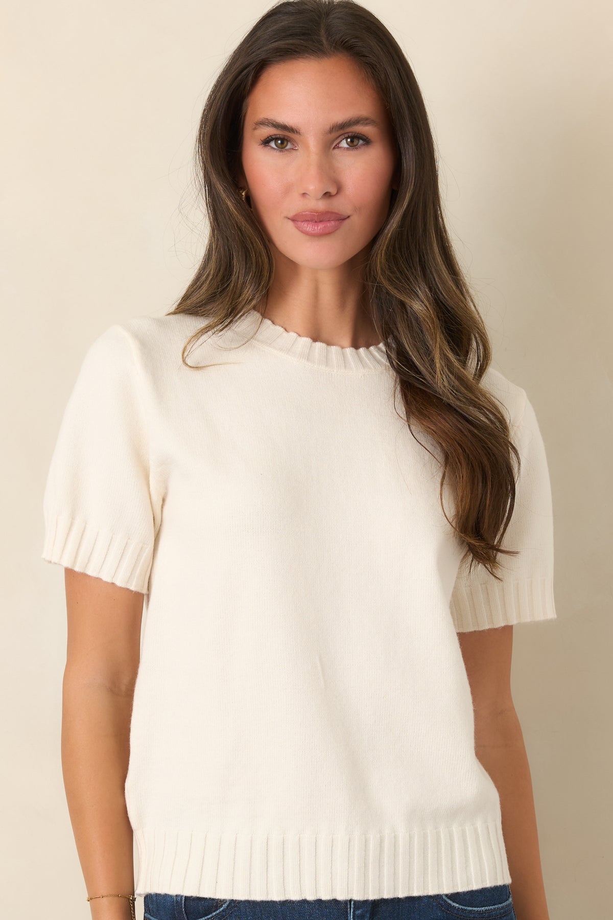 Relaxed ivory knit top featuring short sleeves, a classic crew neckline, and softly textured ribbed edges.
