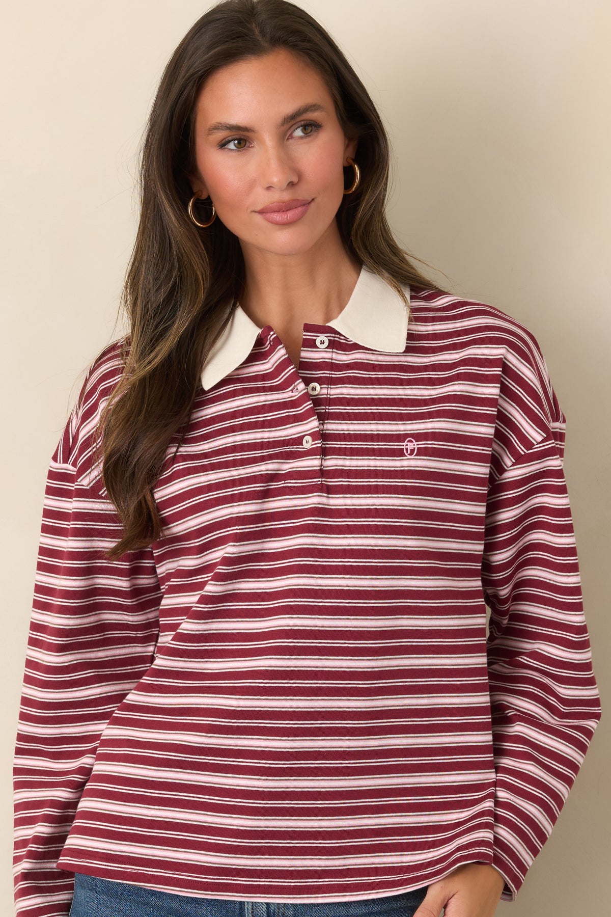 Relaxed ivory striped top with a contrasting point collar, soft cotton construction, and subtle embroidered logo.
