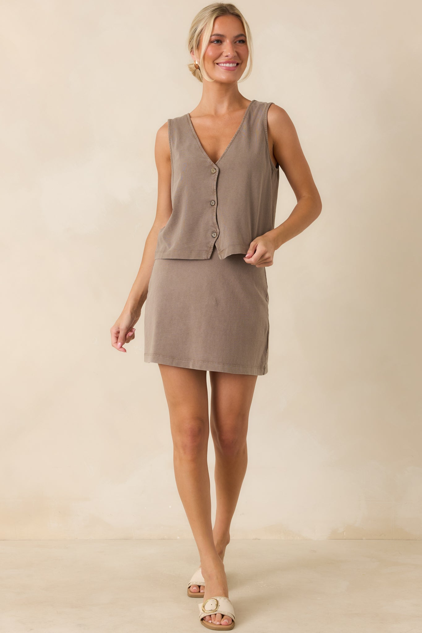 Relaxed yet structured mini skirt in a neutral taupe shade designed with a smooth jersey finish and easy pull-on styling.