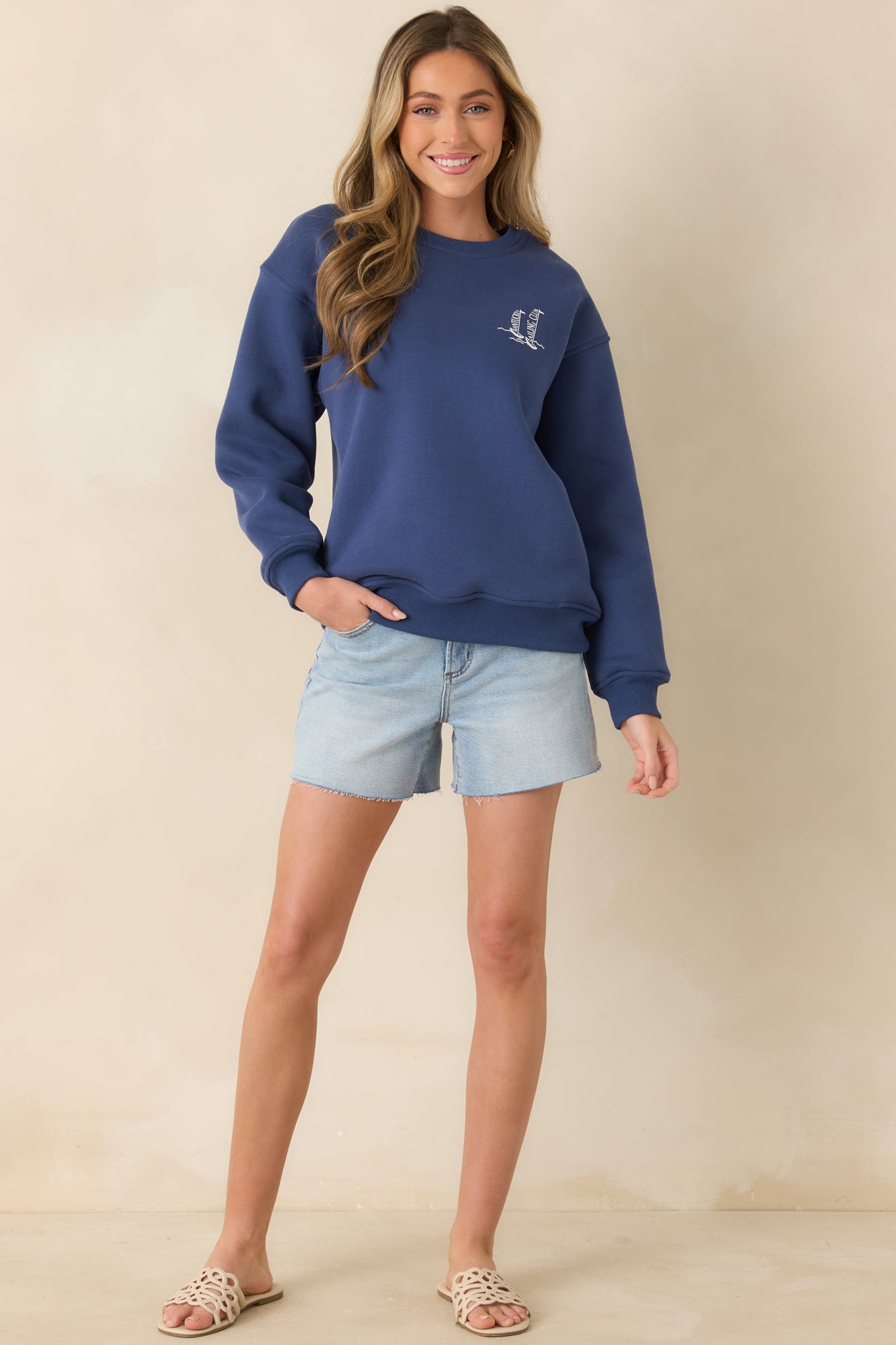 Relaxed navy sweatshirt with front sailboat detail and timeless silhouette.