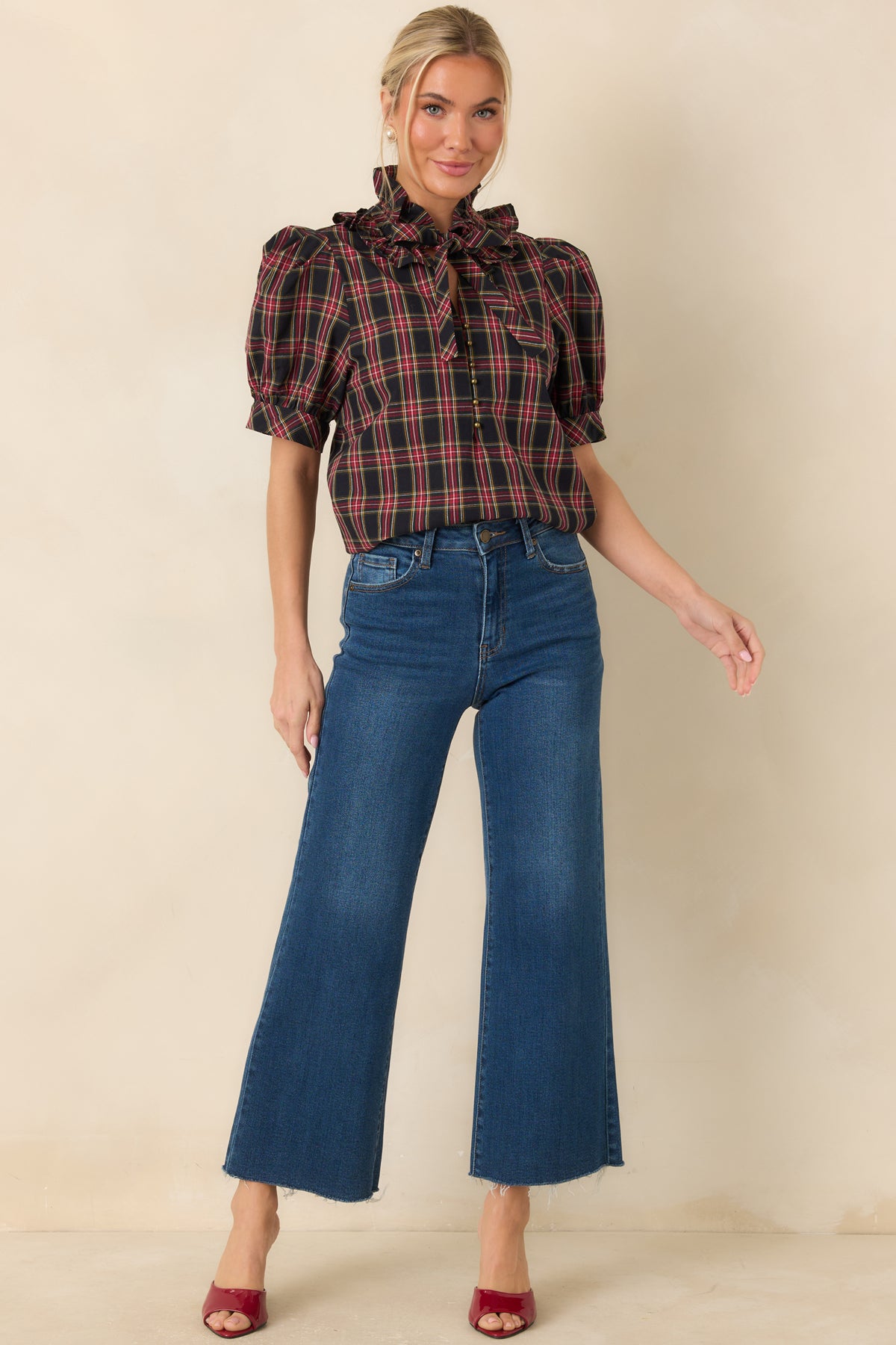 Relaxed plaid blouse with a ruffled collar, button-front opening, and short banded sleeves.