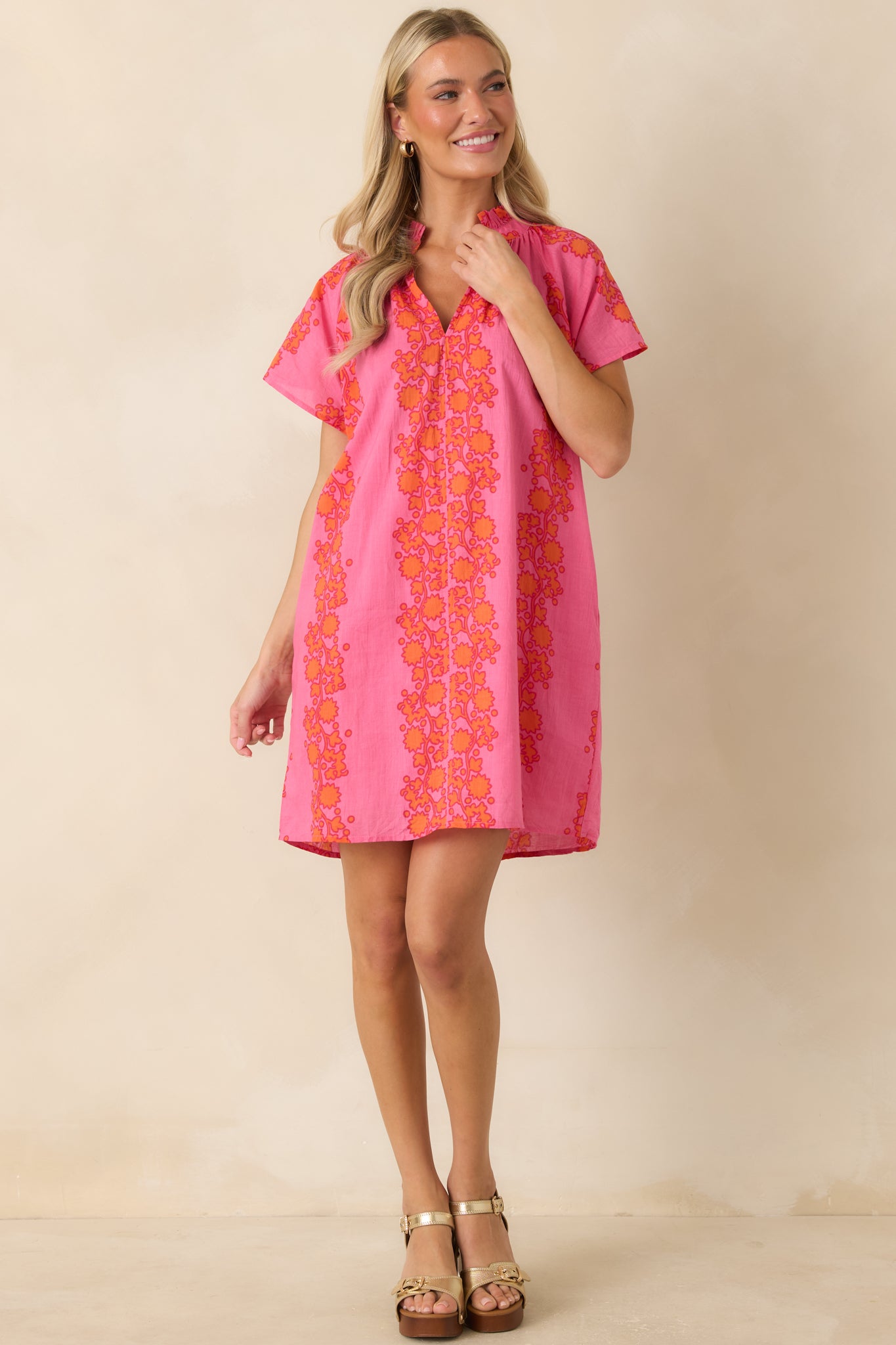 Relaxed shift dress showcasing colorful floral patterns, ruffle neckline details, and functional side pockets.