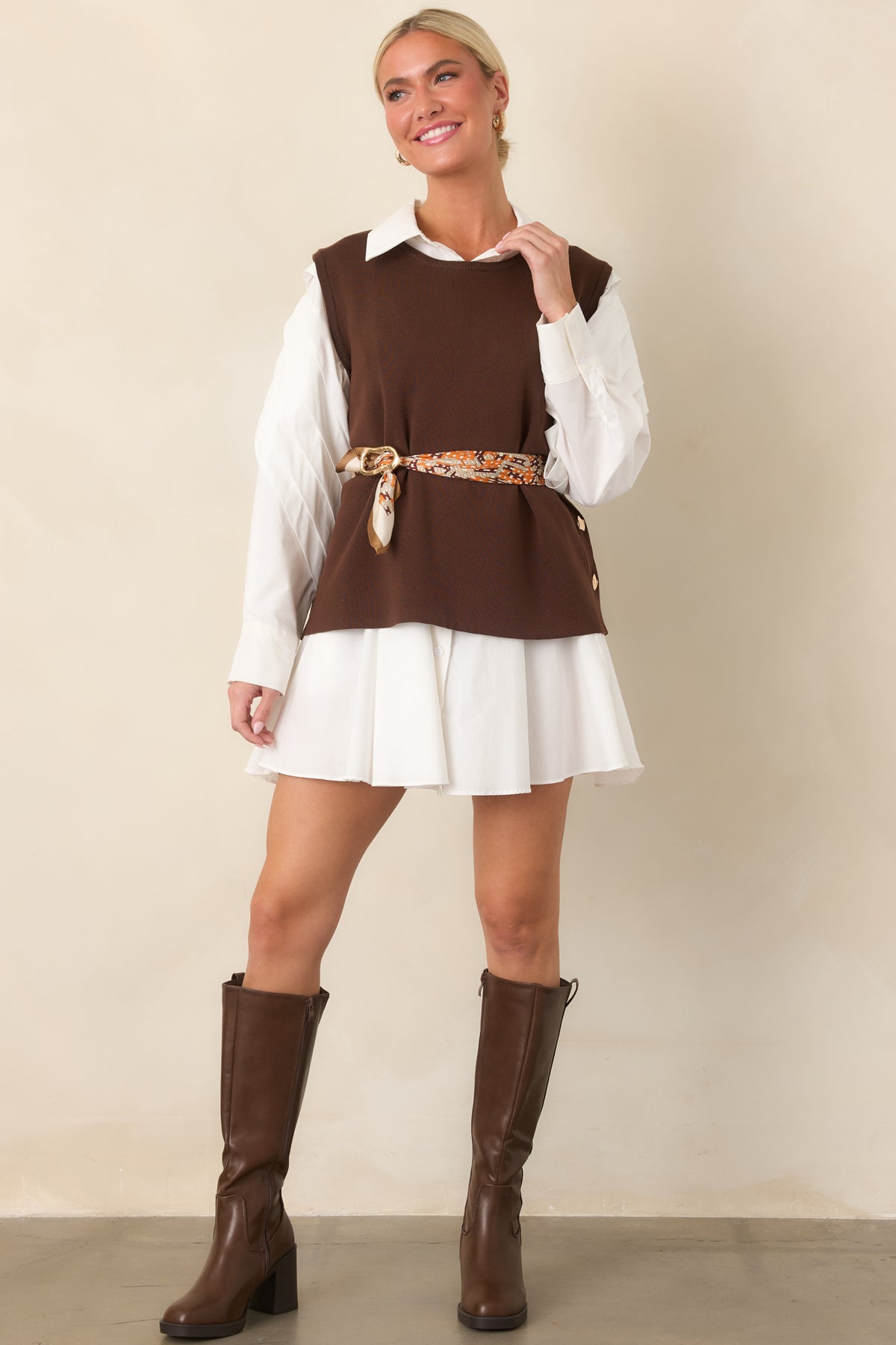 Relaxed sleeveless sweater top featuring smooth knit fabric and a row of gold-tone side buttons.

