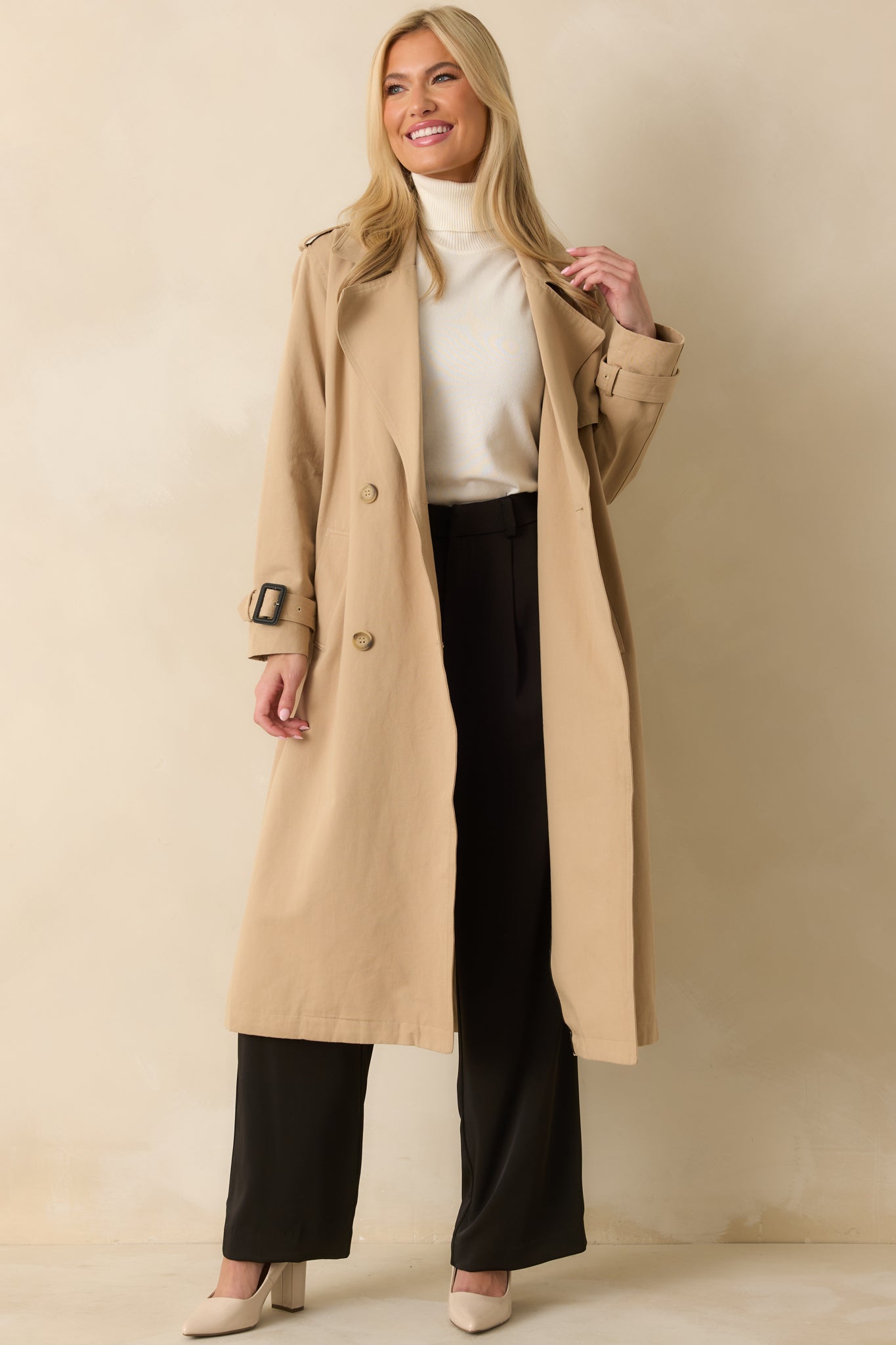 Relaxed fit tan trench coat with polished silhouette, double-breasted front, and mid-length hem.

