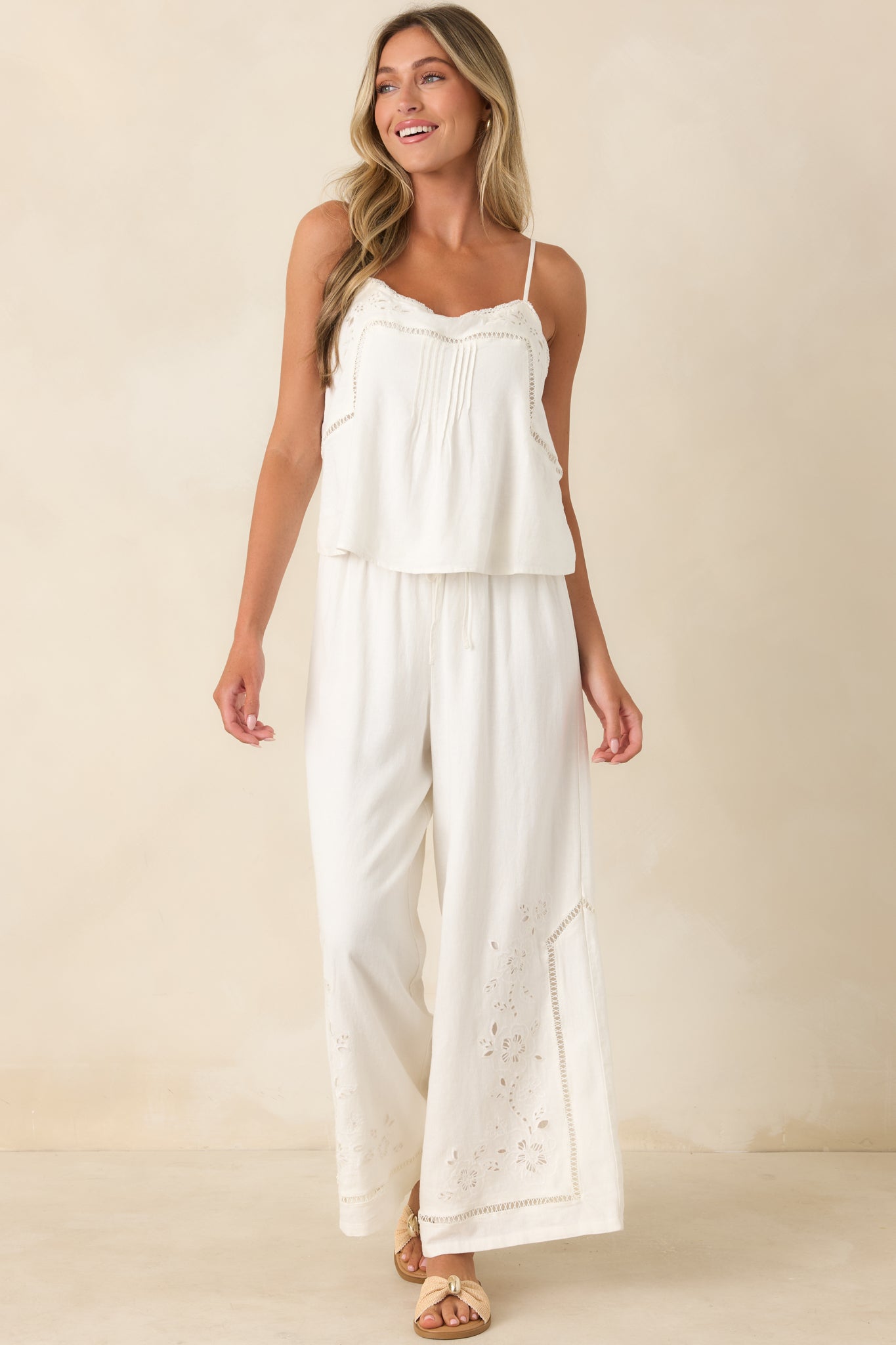 Relaxed wide leg pants showcasing delicate floral embroidery and textured artisanal detailing.